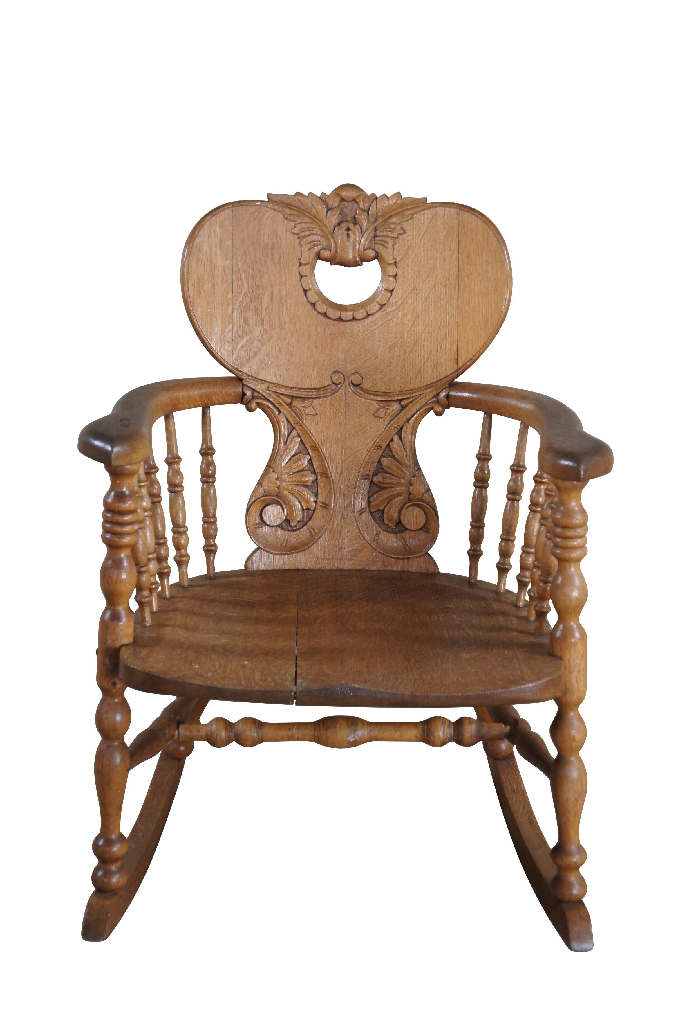 Late Victorian Rocking Chair.  Attributed to Stomps Burkhardt of Dayton, Ohio.  Made from quartersawn oak with a heart shaped back, carved and pierced with acanthus foliate and 