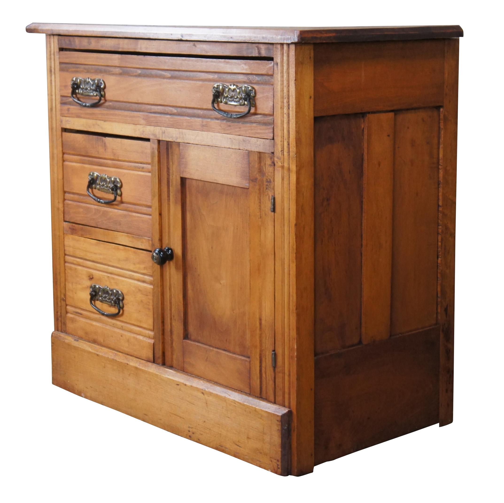 Turn of the century oak washstand featuring three drawers with side cabinet and brass hardware.