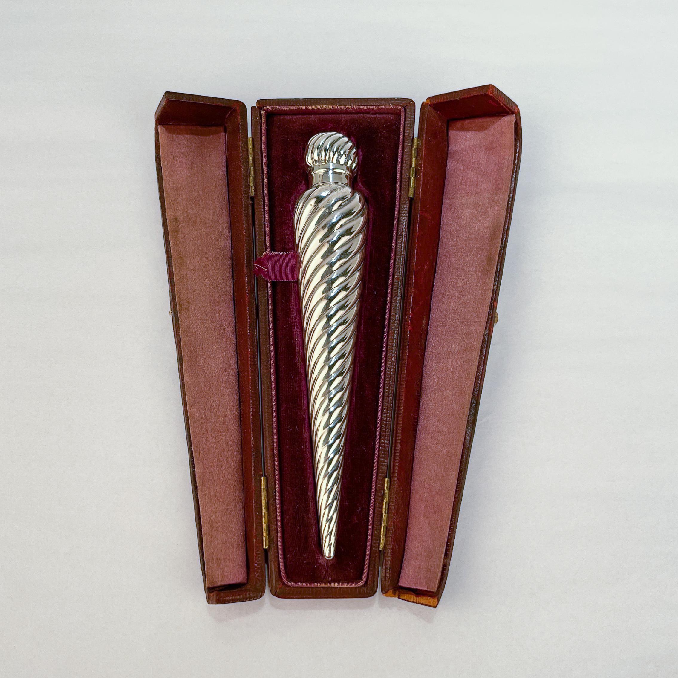 A fine antique English sterling silver perfume flask.

With a tapered spiral form body and a conforming lid.

Made by Gourdel, Vales, & Co. 

Together with its original fitted leather case. 

Simply a wonderful Late Victorian perfume