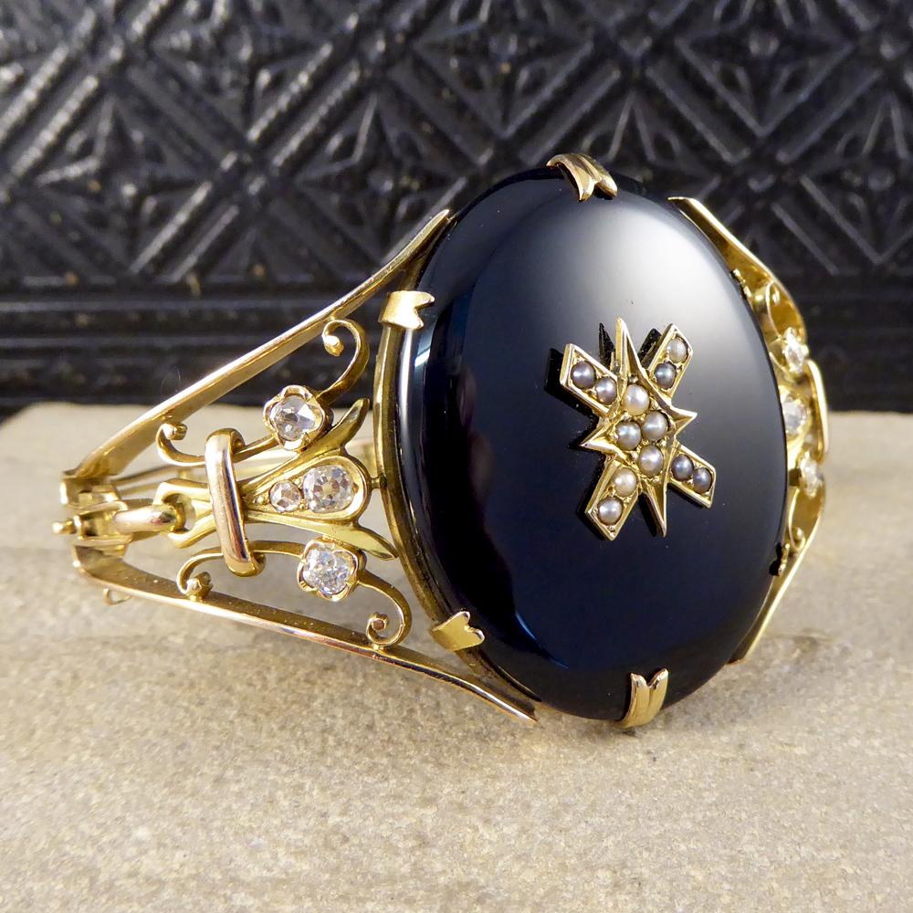 Featuring a large Black Onyx panel this Late Victorian Bangle is beautiful and shows how much quality antique jewellery carries. On the Onyx sits a star/cross pattern on the front created from Seed Pearls which were often associated with purity,