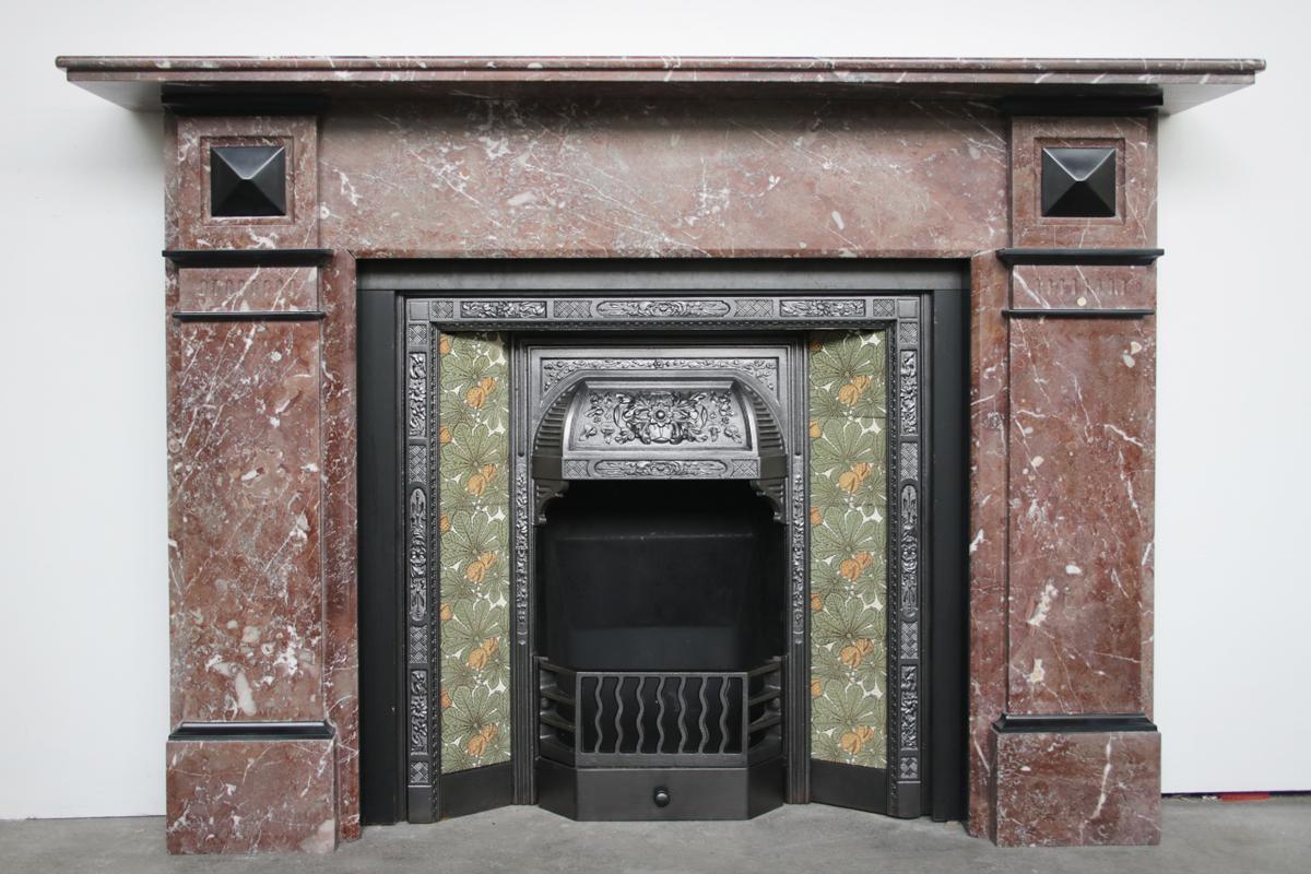 Antique Late Victorian rouge marble fire surround with Belgian black marble ornamentation. English, Circa 1890.

For detailed sizes please see the size diagram in the image gallery.

Pictured with an original late Victorian cast iron and tiled