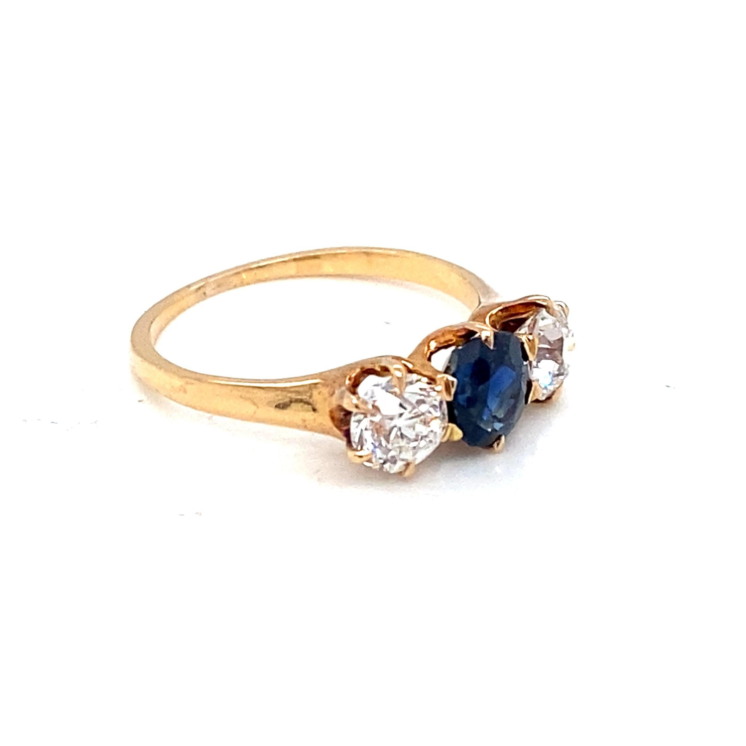 This 14 karat yellow gold antique, circa 1890, late Victorian ring features a straightforward three stone style. The center oval faceted sapphire weighs approximately 0.91 carat and has a lovely deep rich blue color and is flanked on each side by