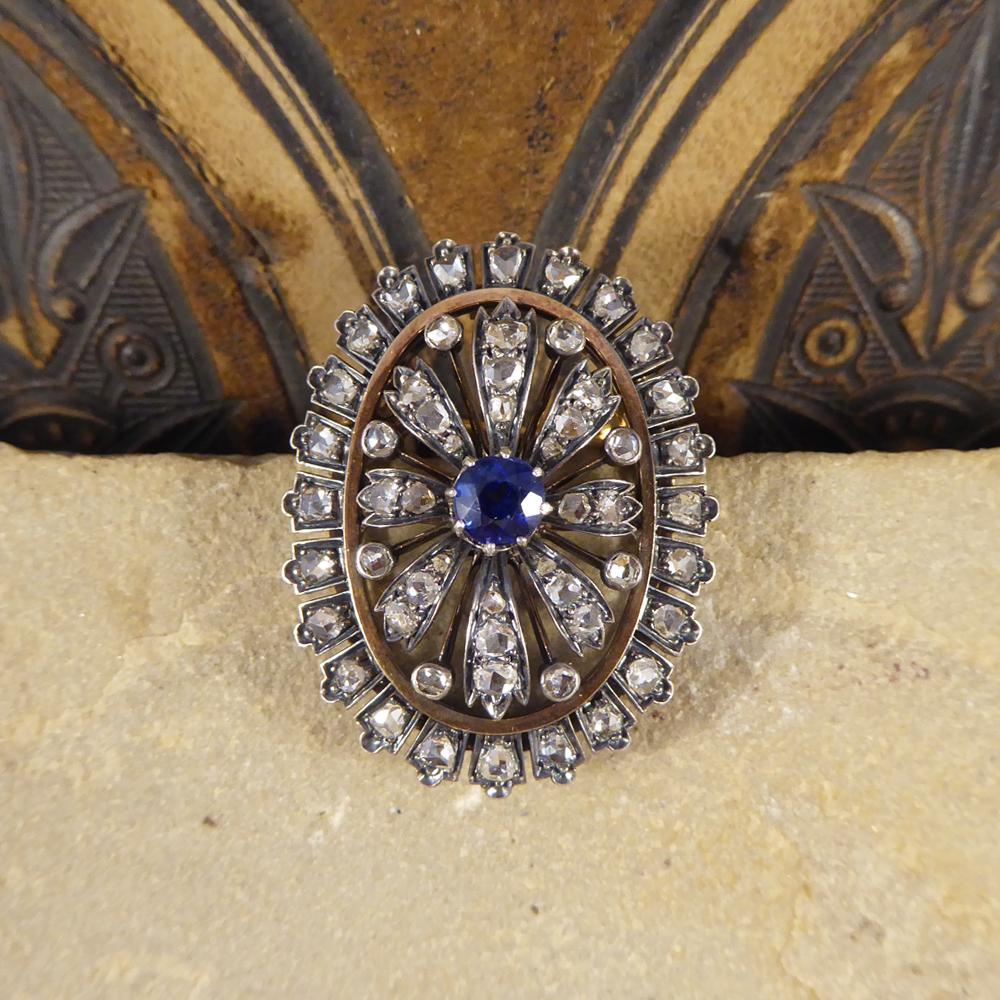 This impressive Sapphire and Diamond Brooch has been handcrafted with a  Yellow Gold back and Silver front. The stones are set in Silver setting to compliment the colour of the stone in the shape of a flower with a single Sapphire weighing
