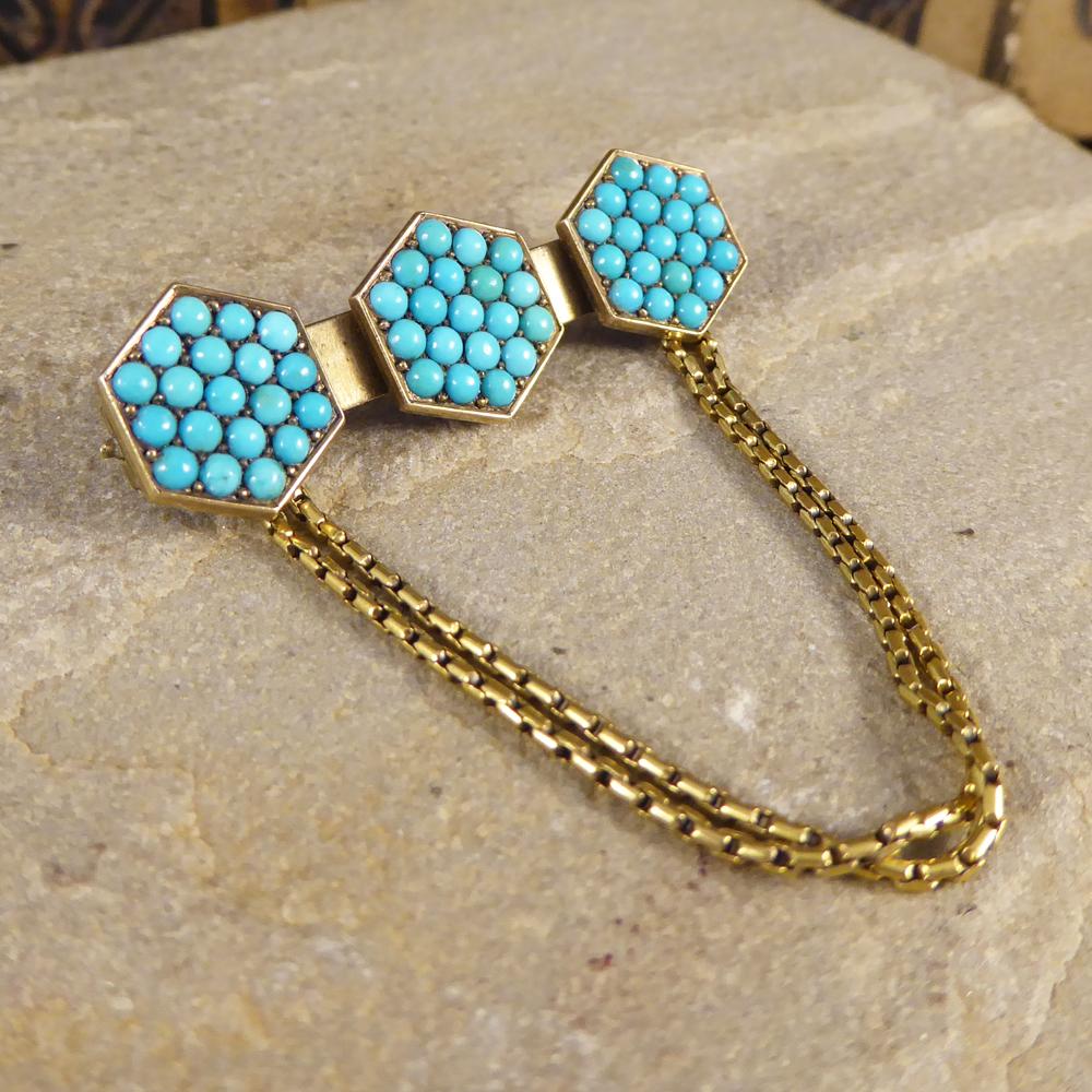 This gorgeous little antique brooch was hand crafted in the Late Victorian era. On the main part of the brooch sits three hexagons adorned with turquoise all crafted in 15ct Yellow Gold with two 15ct Gold chains looped underneath. 

Condition: Very