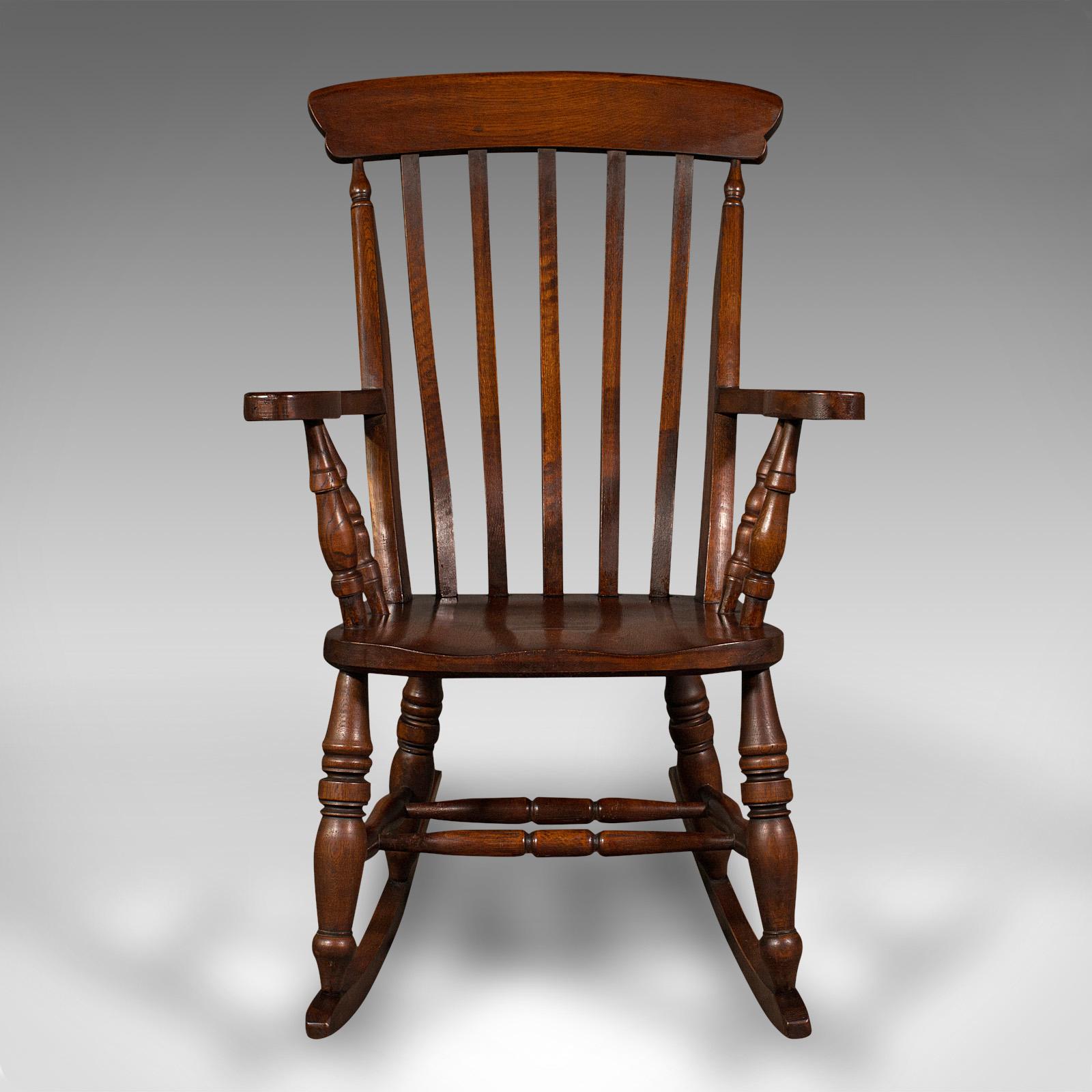 This is an antique lath back rocking chair. An English, oak and beech elbow seat, dating to the Victorian period, circa 1900.

Superb Victorian craftsmanship to this traditionally appealing rocker
Displays a desirable aged patina and in good