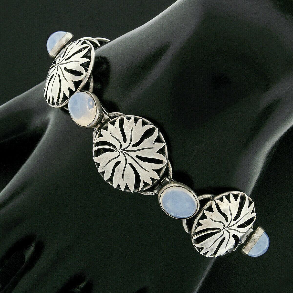 Here we have a gorgeous antique designer bracelet crafted in Denmark by Lauritz Jensen during the art nouveau period. The bracelet is solid 830 silver and features 6 pierced round foliage links which alternate with 6 oval cabochon cut natural