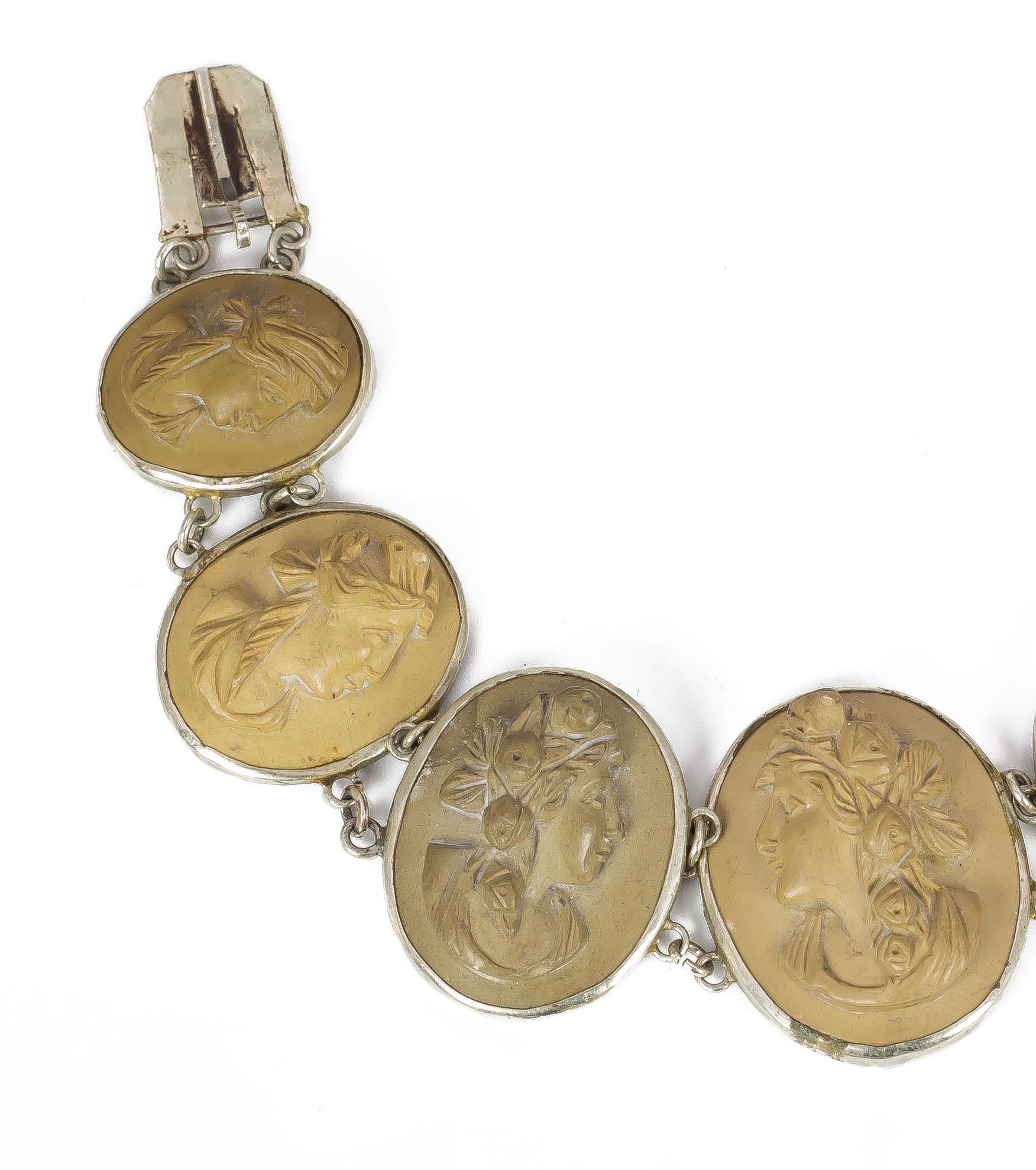 A stunning antique bracelet, decorated with seven oval lava cameos, all in different colours and shades: each one depicts the profile of a beautiful woman, with collected hair, and some of them with floral decorations in their hair. The cameos are