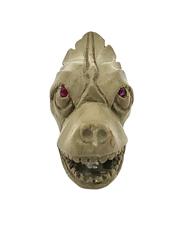 Dieser Drachen- oder Hundekopf wurde in einer der Werkstätten in der Region Neapel, die sich auf das Schnitzen von Souvenirs für große Reisen spezialisiert haben, von Hand aus Lava geschnitzt.  Die Augen des Hundes sind aus rotem Glas gefertigt