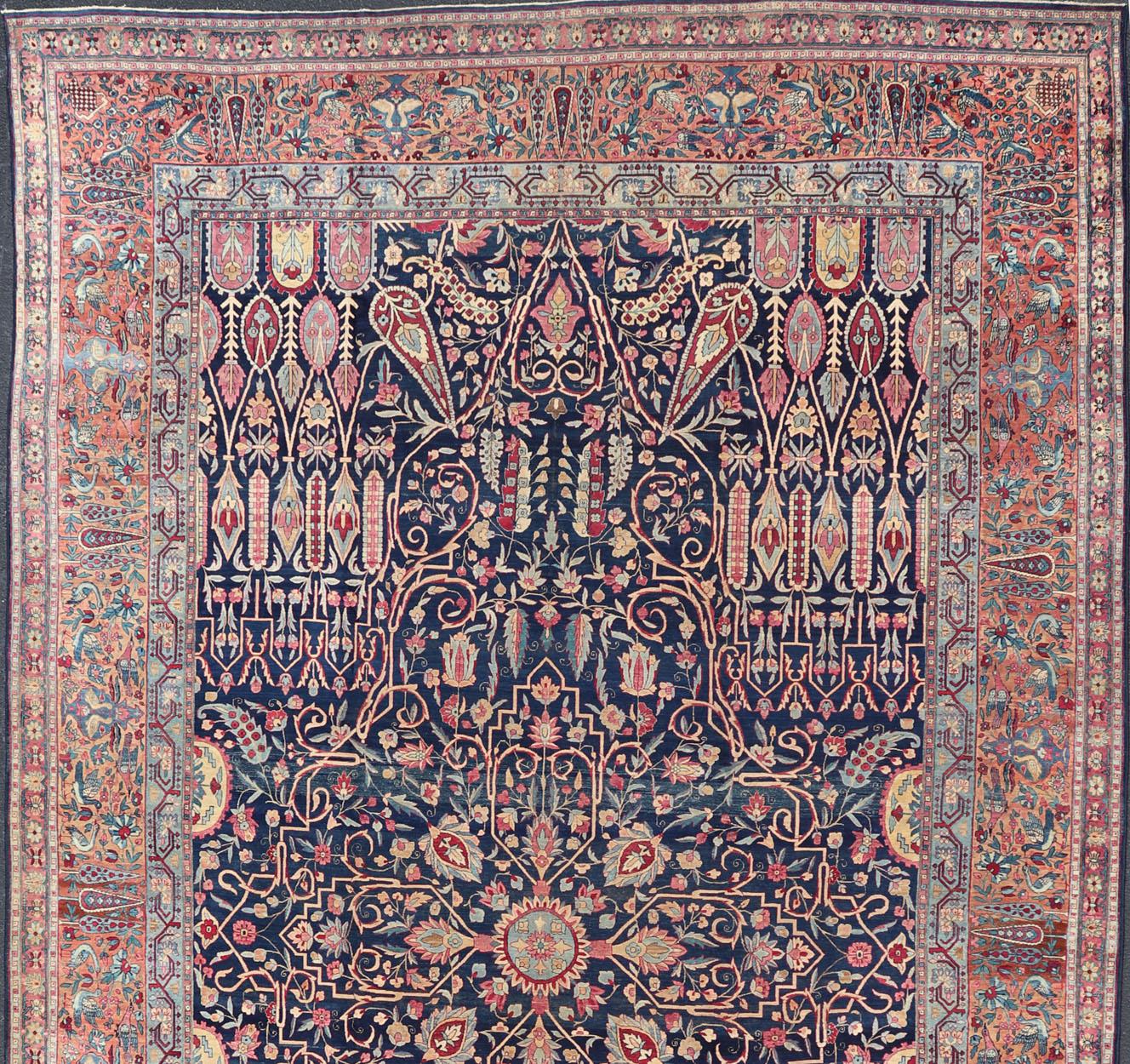 Mesures : 11'7 x 19'2

Ce magnifique tapis ancien de Lavar Kerman est orné d'un exquis motif floral couvrant, entouré d'une bordure complémentaire à plusieurs niveaux. Ce tapis contient un fond bleu marine rempli de  des motifs et des fleurs. La