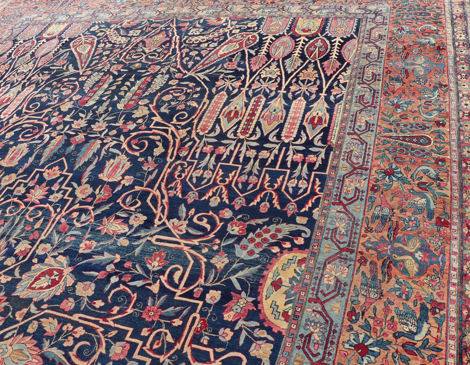 Noué à la main Tapis persan ancien Lavar Kerman avec un motif floral sur un champ bleu en vente