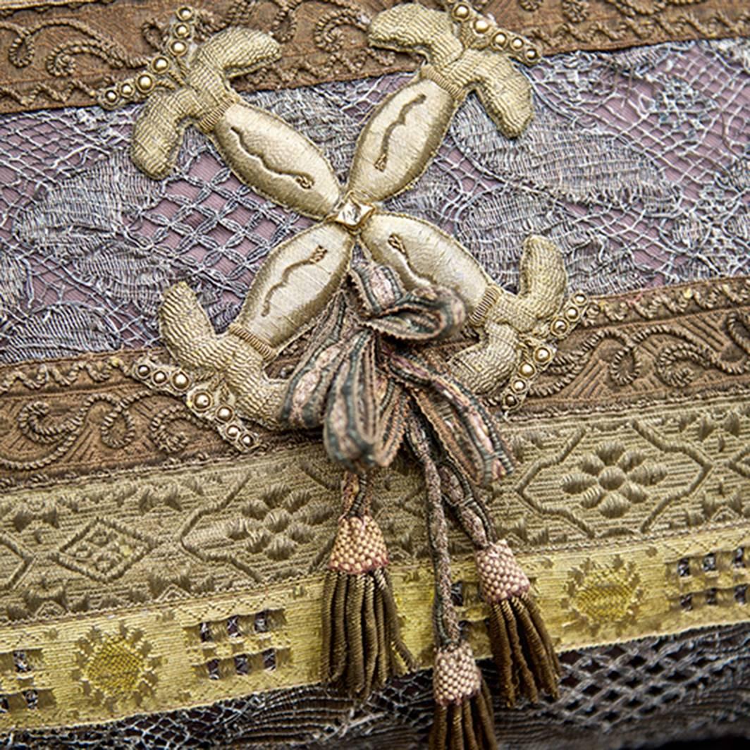 Italian chestnut colored silk pillow with a horizontal composition of layers of antique Italian and French trim of various periods and types dating back as far as the 18th century. The center and outermost stripes are 18th century French silver lace