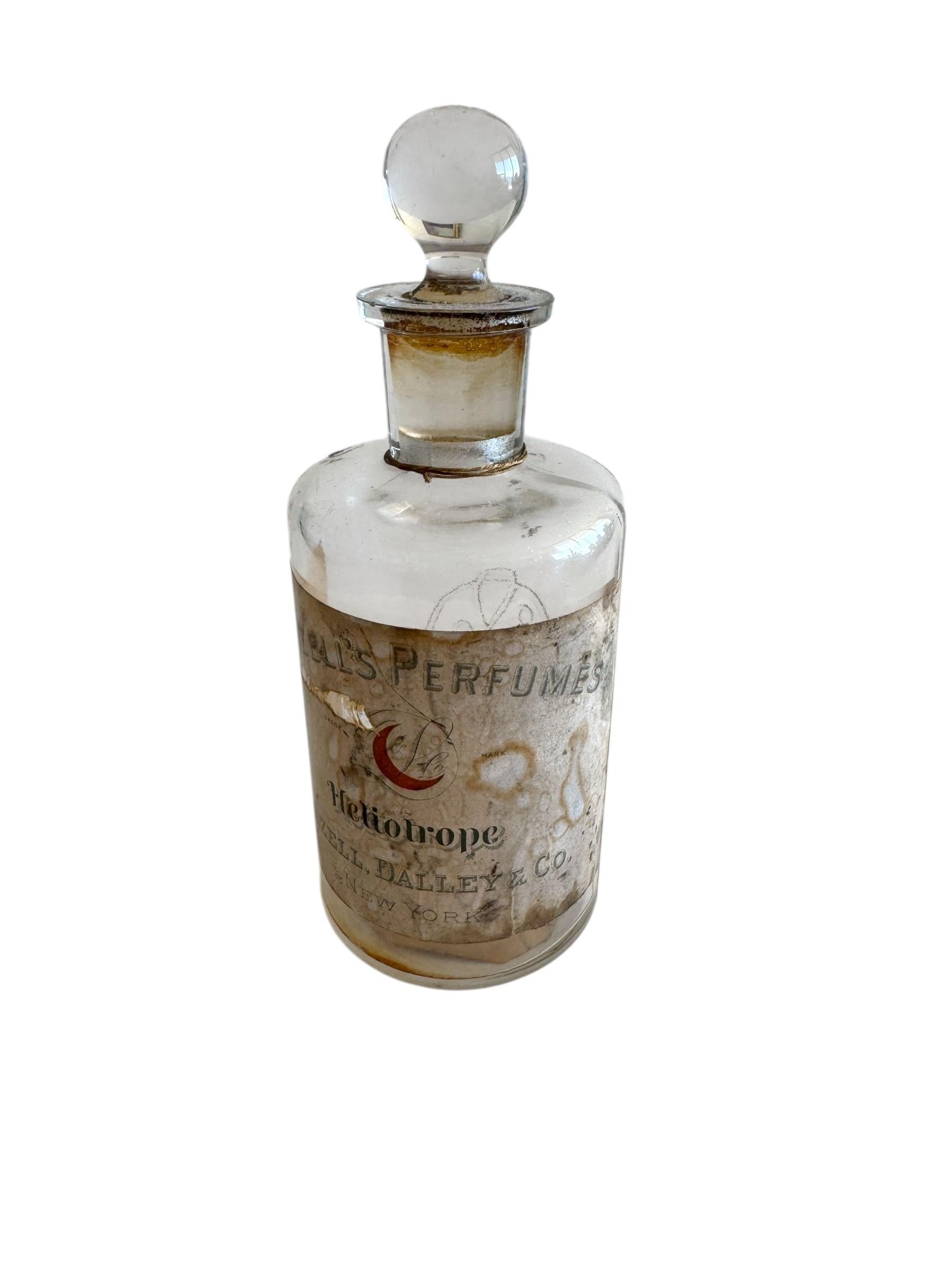 A rare surviving example of 19th century American perfumery, this Lazell, Dalley & Co. “Heliotrope” perfume bottle dates to the 1880s. The clear glass bottle retains its original label with ornate typography and decorative detailing, reflecting the