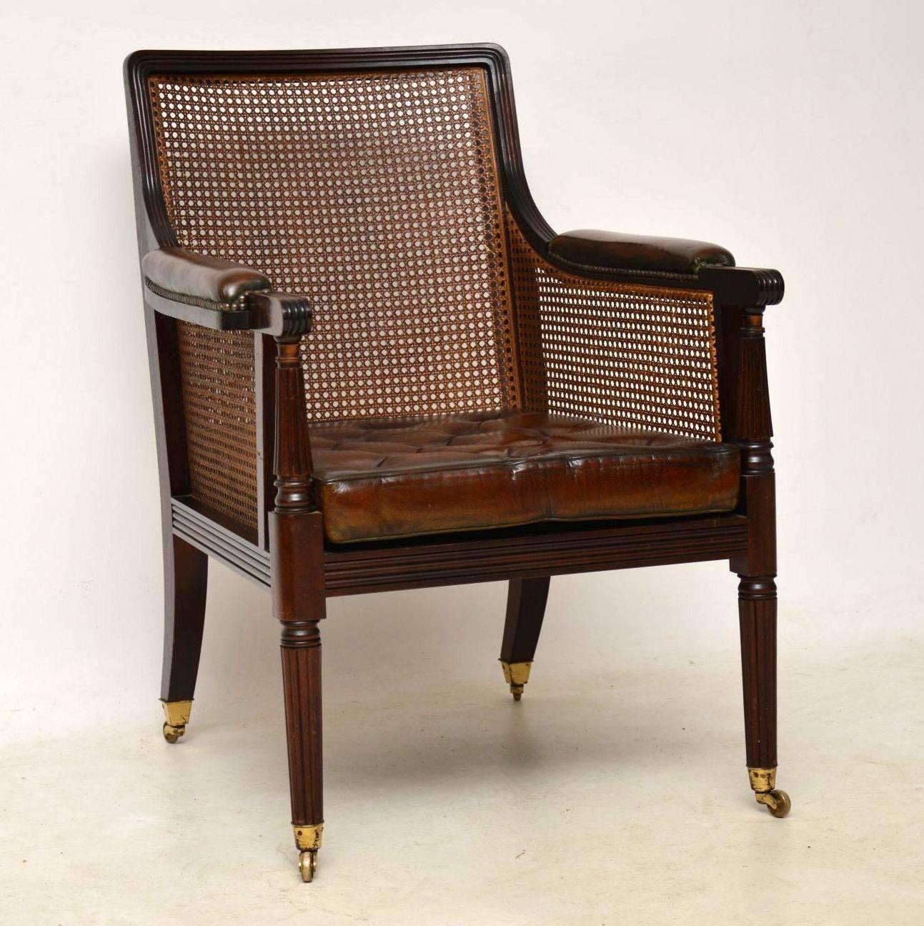 Antique Regency style mahogany bergere library armchair, with buttoned leather cushions, plus cane sides and back. It’s of high quality and in excellent condition. At first glance this chair does look like an original Regency piece, but it is in