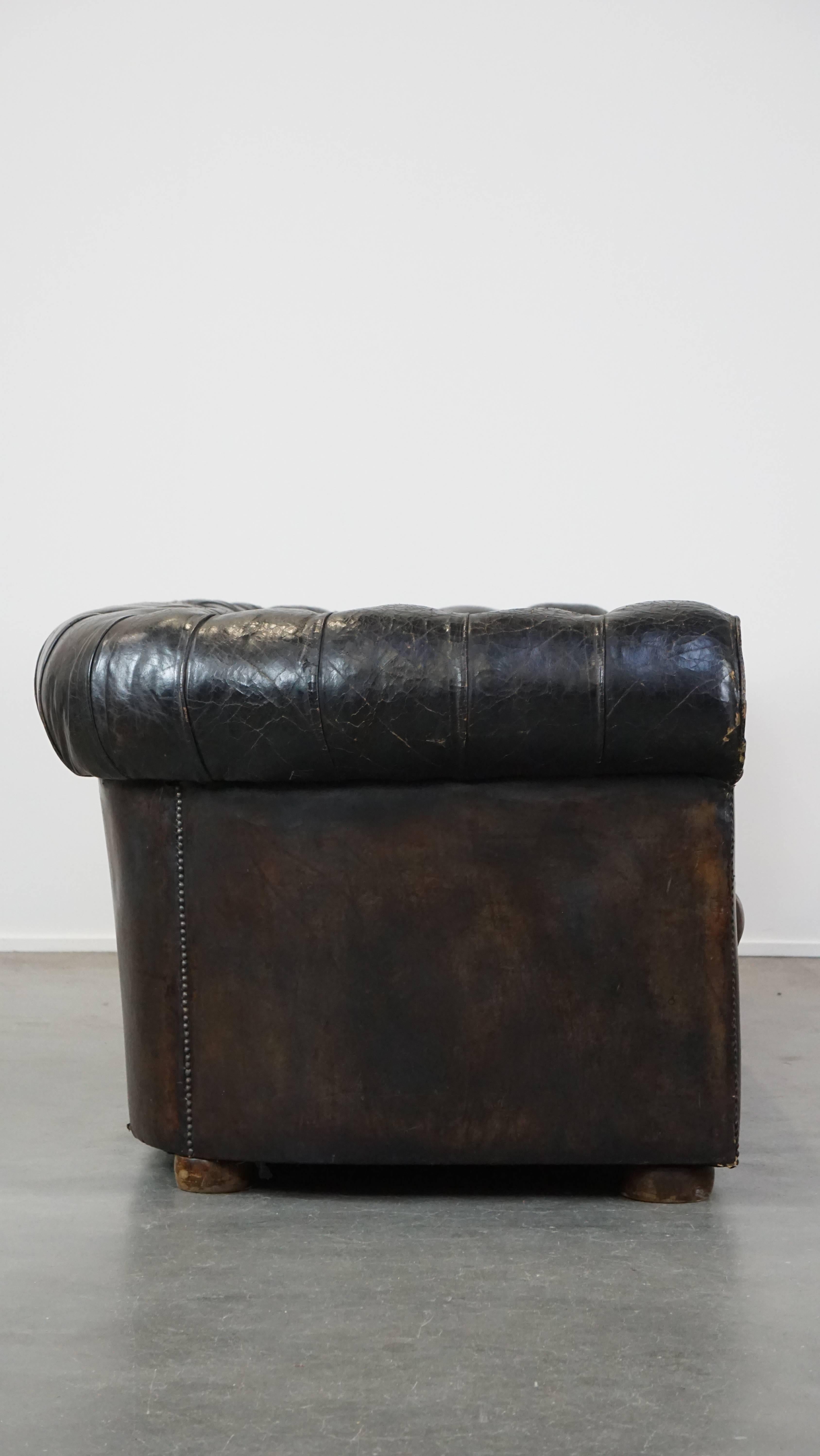 Ce superbe canapé Chesterfield 3 places en cuir ancien est l'incarnation du luxe ultime. Le dossier et les accoudoirs sont en cuir d'origine, tandis que le siège a été retapissé à un moment donné. Le siège est un siège dit 