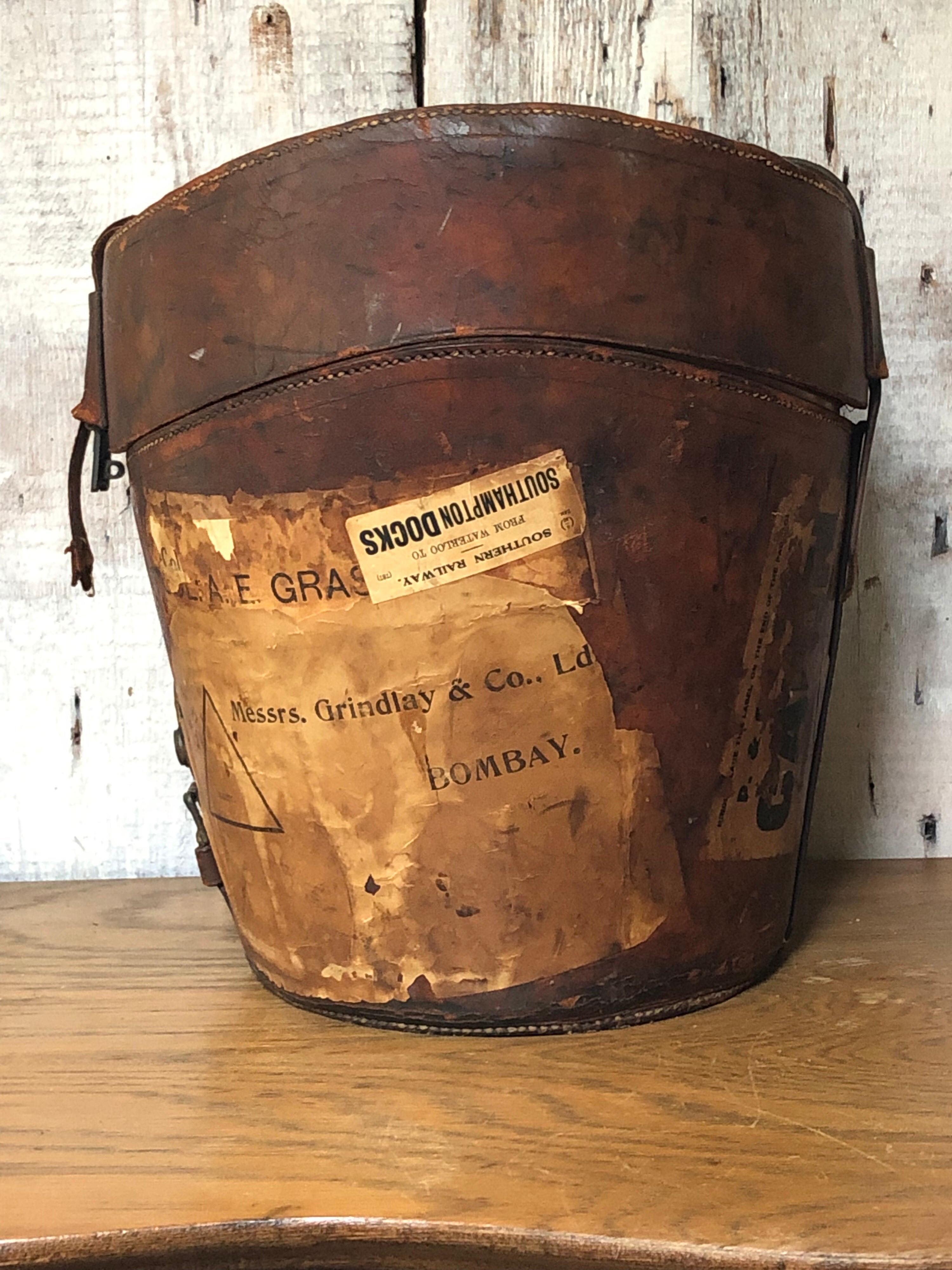 This antique leather hat box still carries remnants of its travels to the East Indies, circa 1858. The hat box is quite large with space inside for two regular top hats placed upside down and space inside the lid for a collapsible top hat.

The
