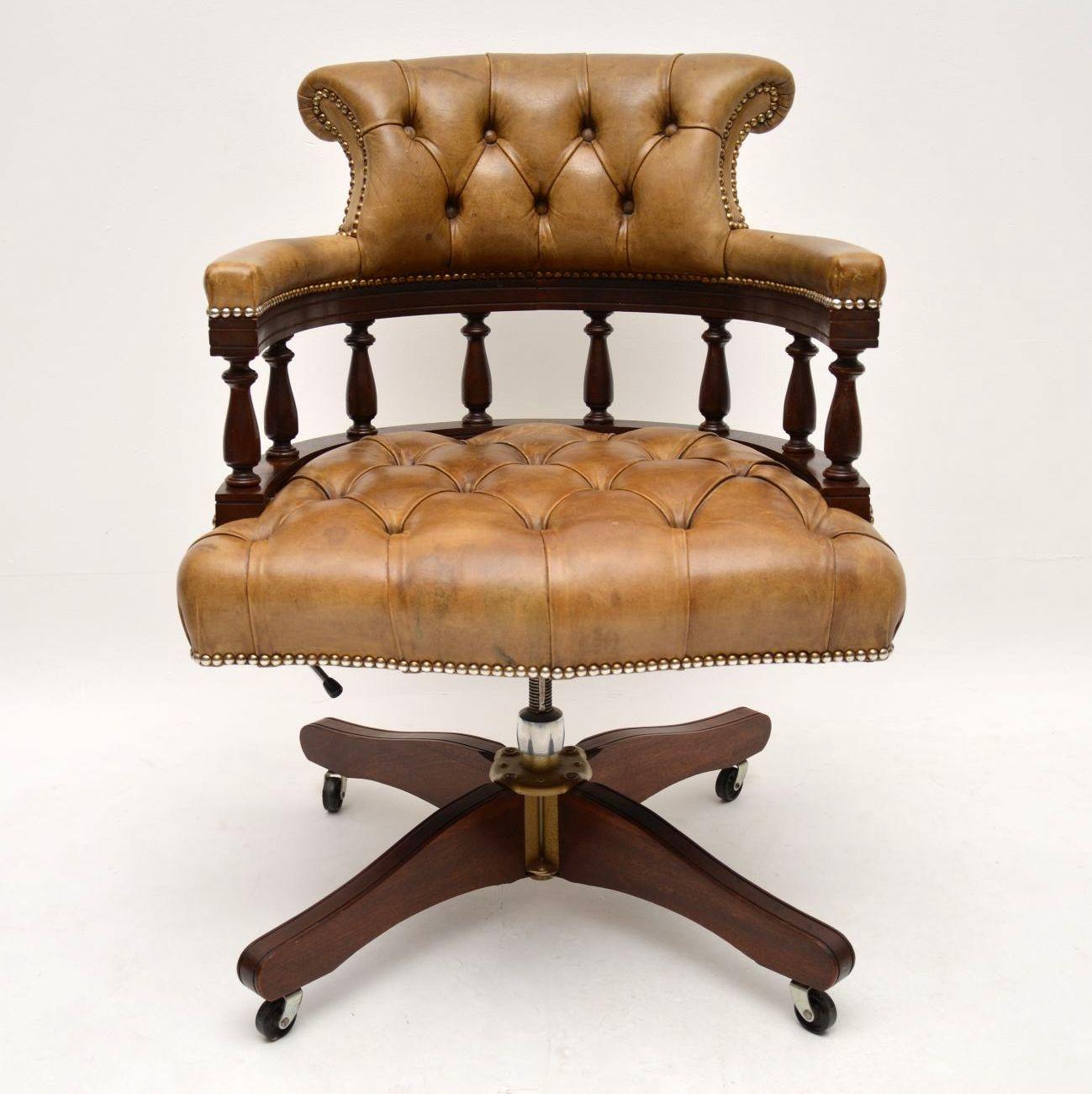 Antique Victorian Captains style desk armchair in good condition. This chair swivels, tilts back and can be adjusted in height. The leather is deep buttoned, in good condition and has a wonderful old tan color. The leather is naturally distressed