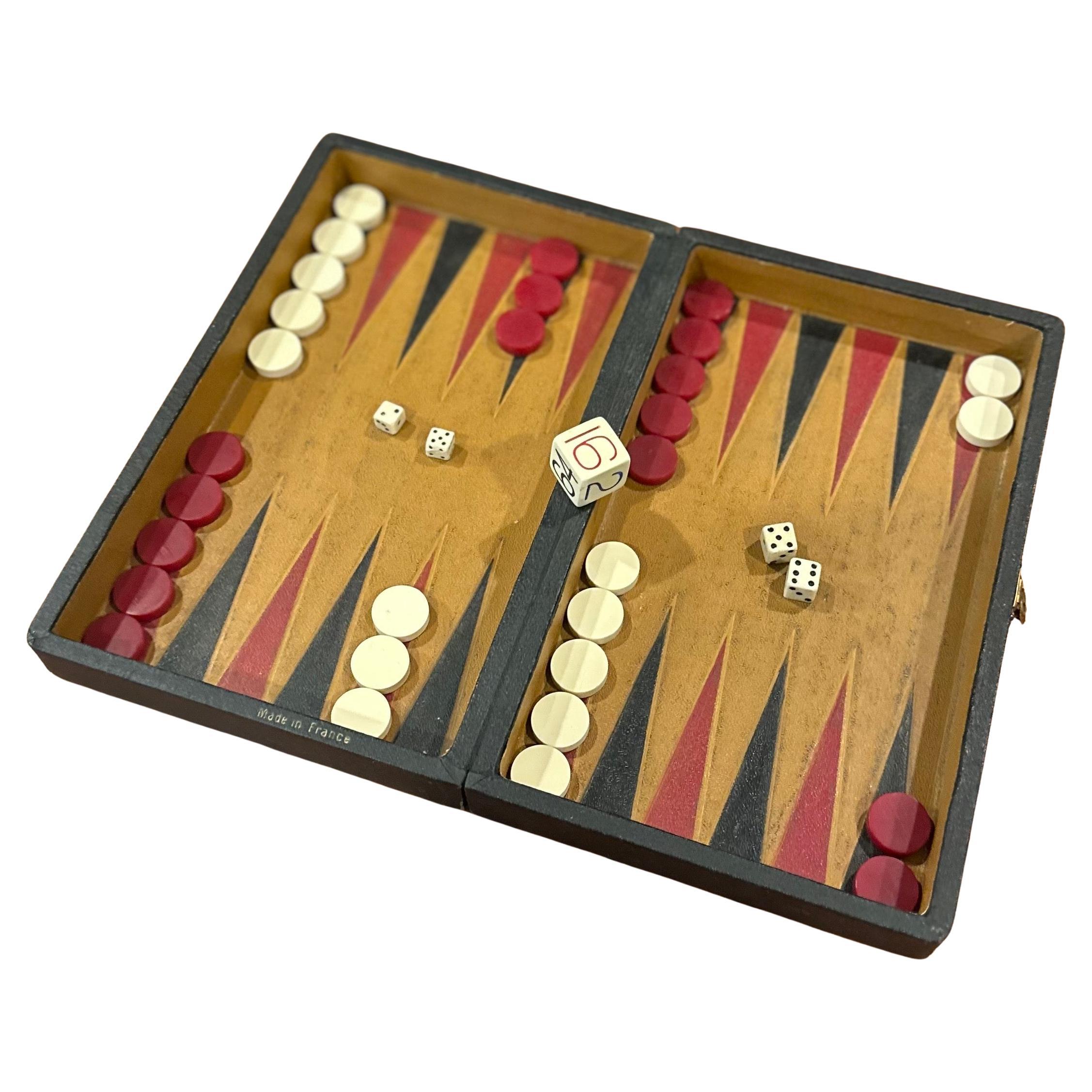 Rarísimo juego de backgammon / damas de viaje antiguo de cuero y baquelita, circa años 20. El juego se completa con un estuche/tablero plegable forrado de cuero con 30 fichas de baquelita (de color crema y rojo, de 0,625 