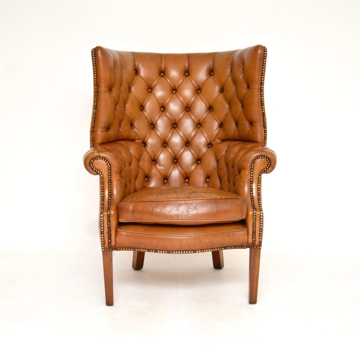 Magnifique fauteuil à oreilles en cuir ancien à dossier en tonneau. Fabriqué en Angleterre, il date du début du XXe siècle, probablement des années 1930.

Il est d'une superbe qualité, ses proportions sont généreuses et il est extrêmement