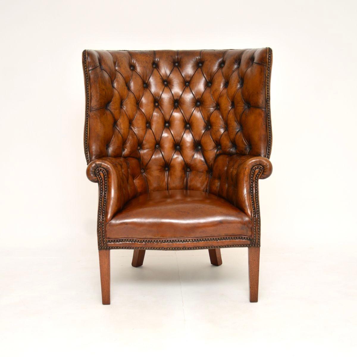 Magnifique fauteuil à oreilles en cuir ancien à dossier en tonneau. Fabriqué en Angleterre, il date du début du XXe siècle, vers les années 1920.

Il est d'une superbe qualité, ses proportions sont agréables et il est extrêmement confortable. Le