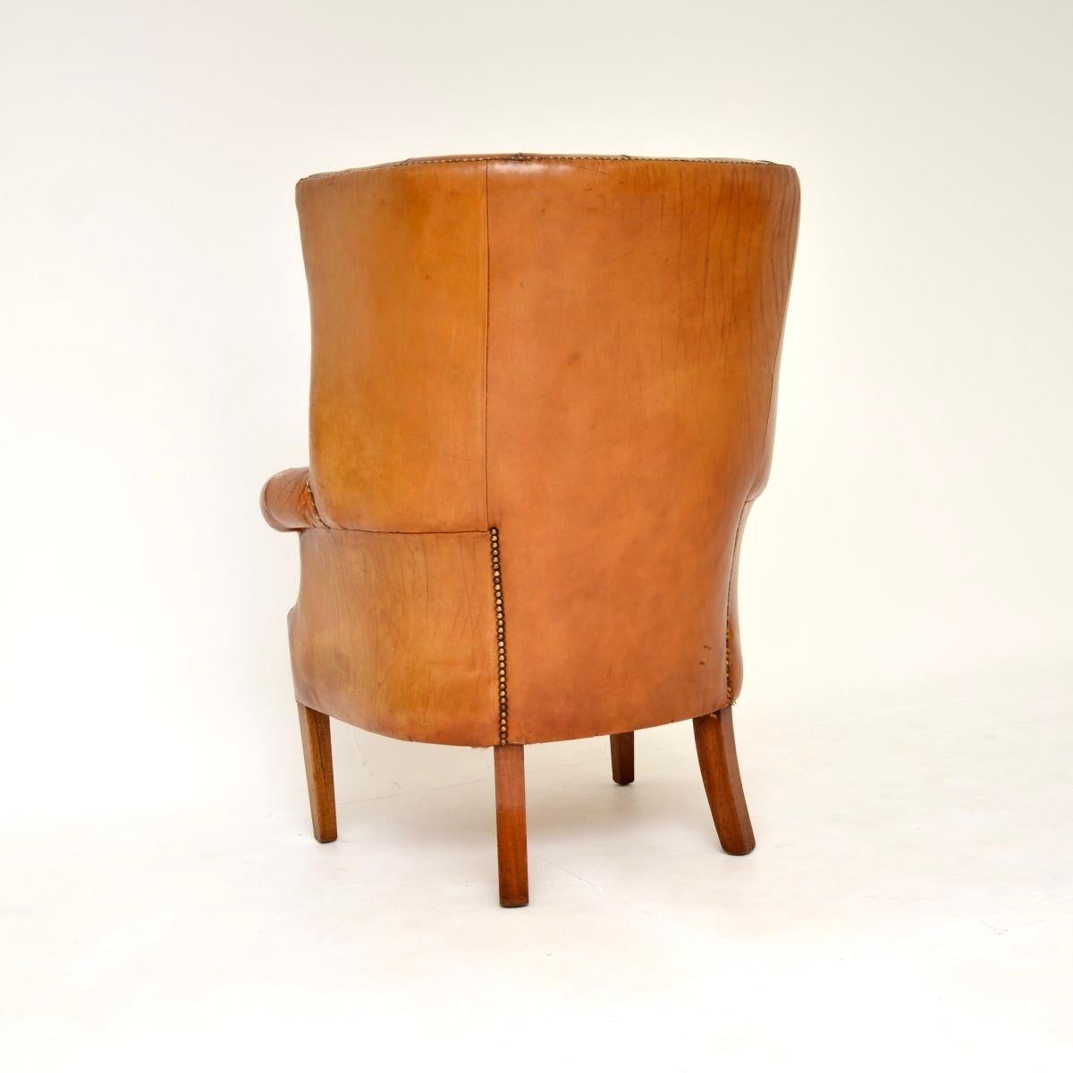 Milieu du XXe siècle Fauteuil à oreilles en cuir antique à dossier en forme de tonneau en vente