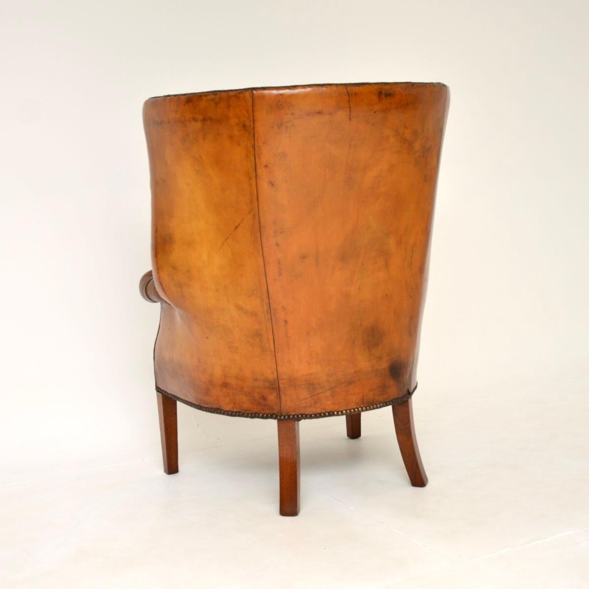 Début du 20ème siècle Fauteuil à oreilles en cuir antique à dossier en forme de tonneau en vente