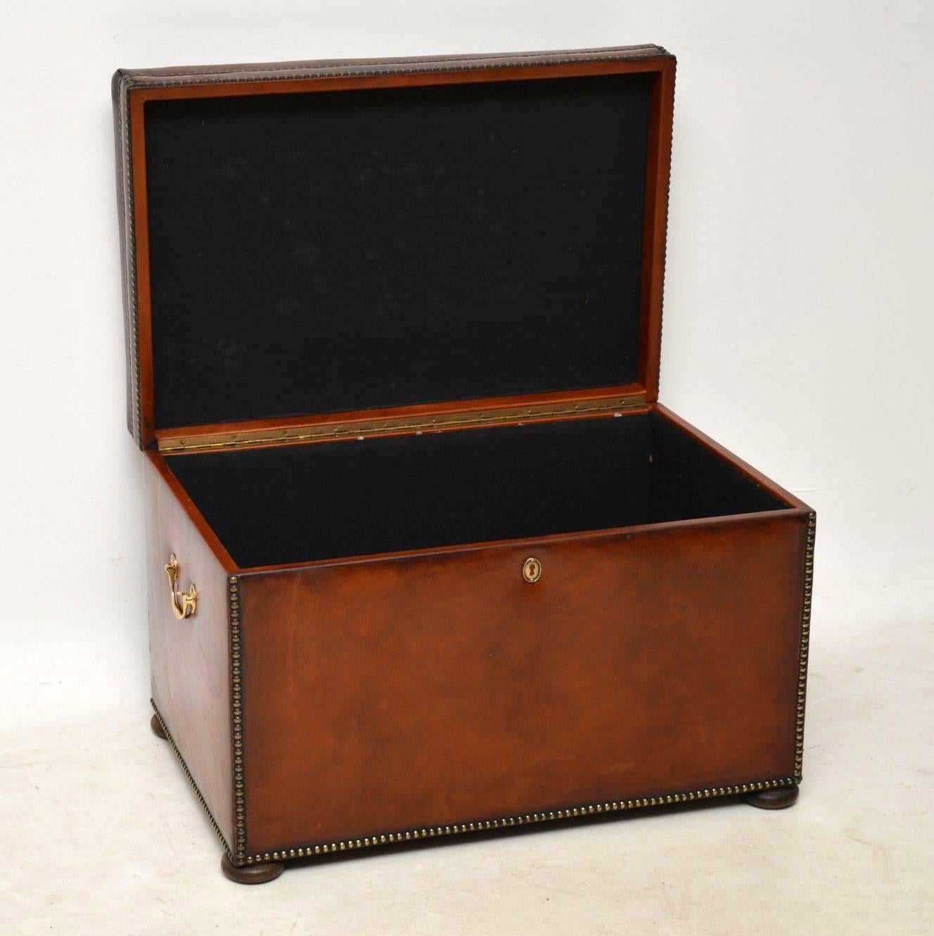 Antique Victorian style hand colored leather trunk in excellent condition with a lift up seat and plenty of storage inside. The leather is all hand tacked onto the frame and there are brass handles on the sides. This trunk sits on flat bun feet.
