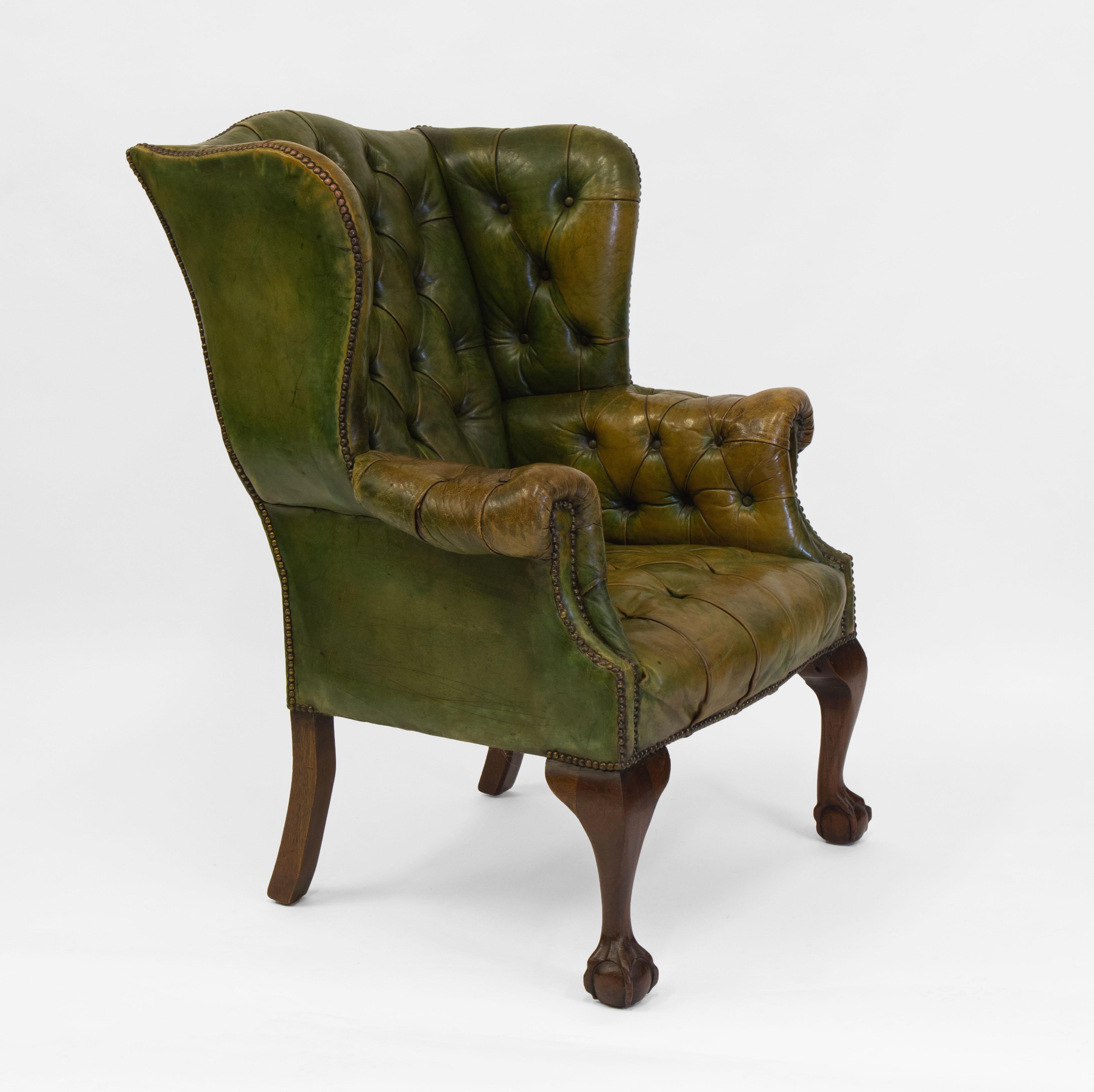 A fabulous antique green leather button wing back armchair, standing on hand carved claw and ball feet to the front. In the Georgian style. Circa 1920’s.

Showing wonderful patina and natural discolouration to the leather, there are scuff marks