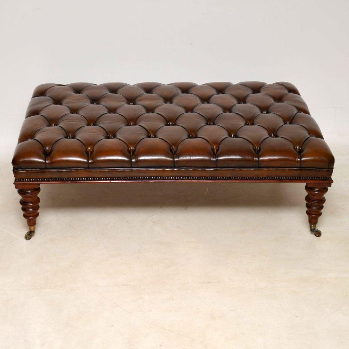Very impressive large antique Victorian style deep buttoned leather stool or coffee table with a mahogany edge and sitting on well turned mahogany legs with brass cup casters, which have been antiqued. It has been beautifully re-upholstered, then