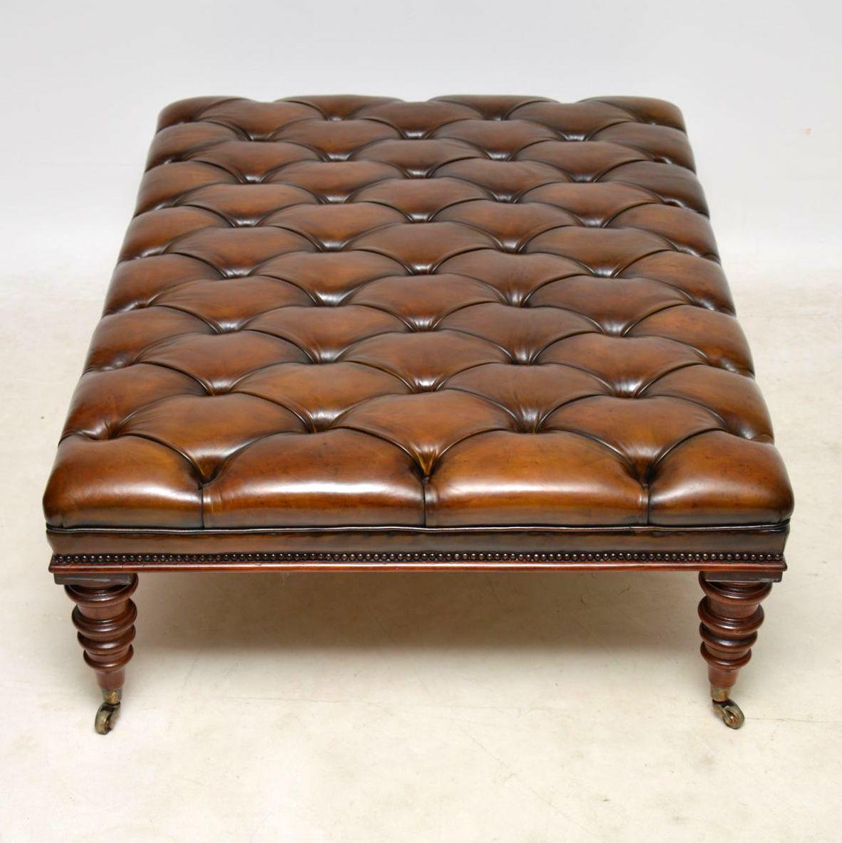 This is one of our large antique Victorian style deep buttoned leather stools or coffee tables with a mahogany edge and sitting on well turned mahogany legs with brass cup casters, which have been antiqued. It has been beautifully re-upholstered,