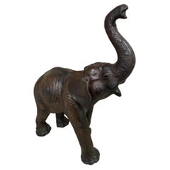 Scultura antica di elefante in pelle con occhi di vetro