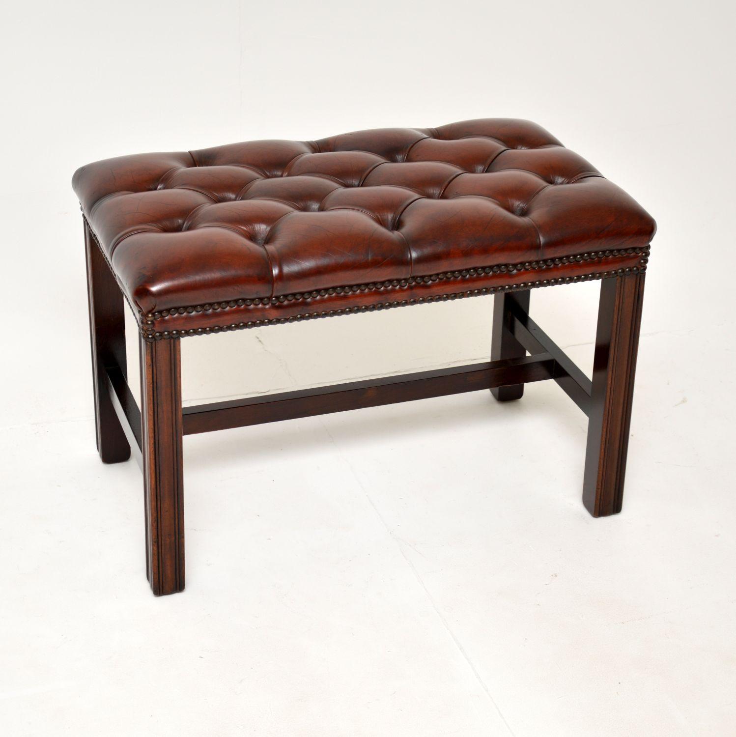 A fantastic antique deep buttoned leather footstool on a wooden base. This is in the classic Georgian style, it was made in England and dates from around the 1920-1930’s period.

It is of super quality and is a very useful size, perfect for use