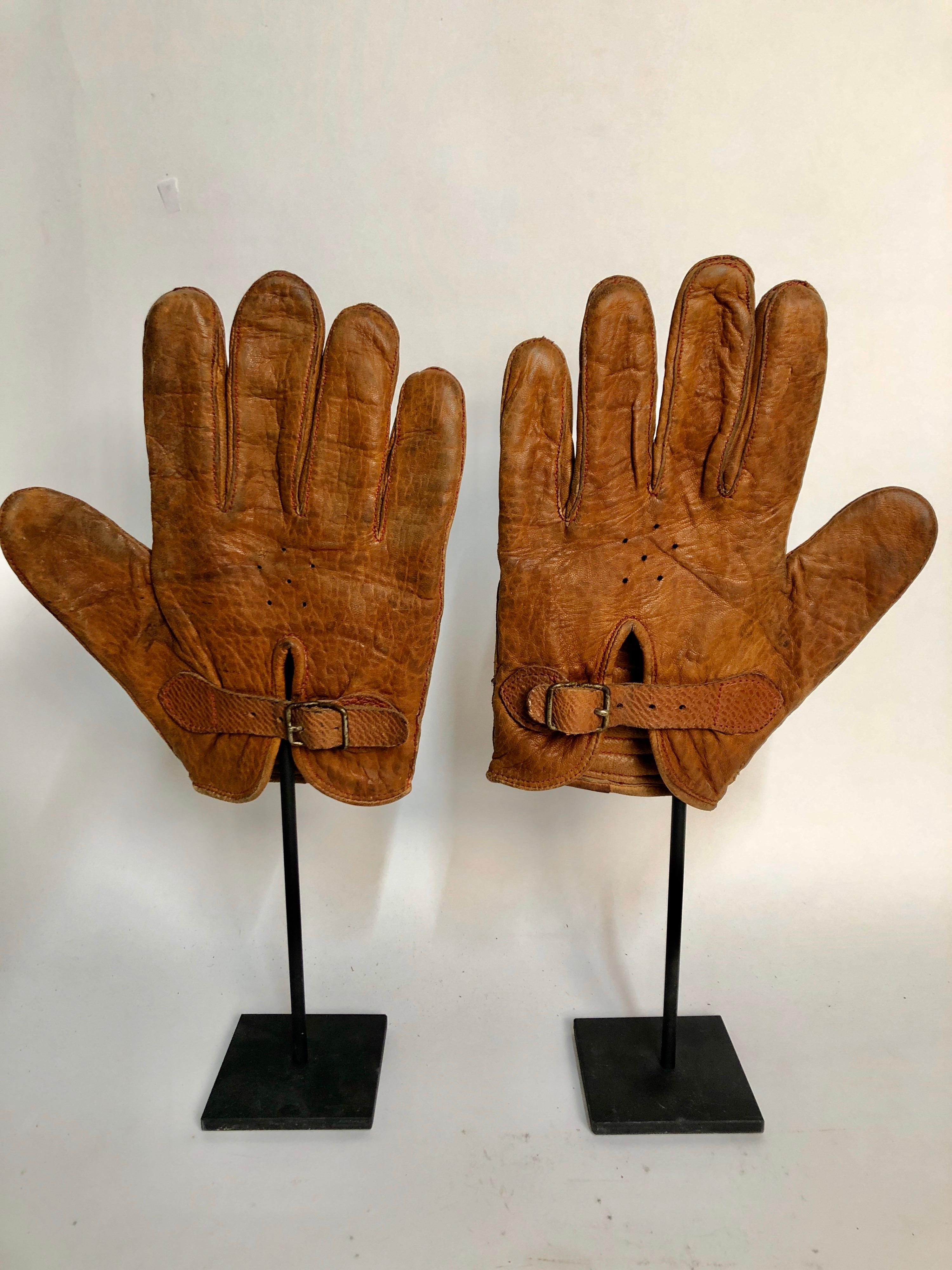 A pair of early American leather handball gloves with great optical patterns. Mounted on custom made steel stands. Measure: 14.5 x 7 x 3. Probably made by Spaulding.