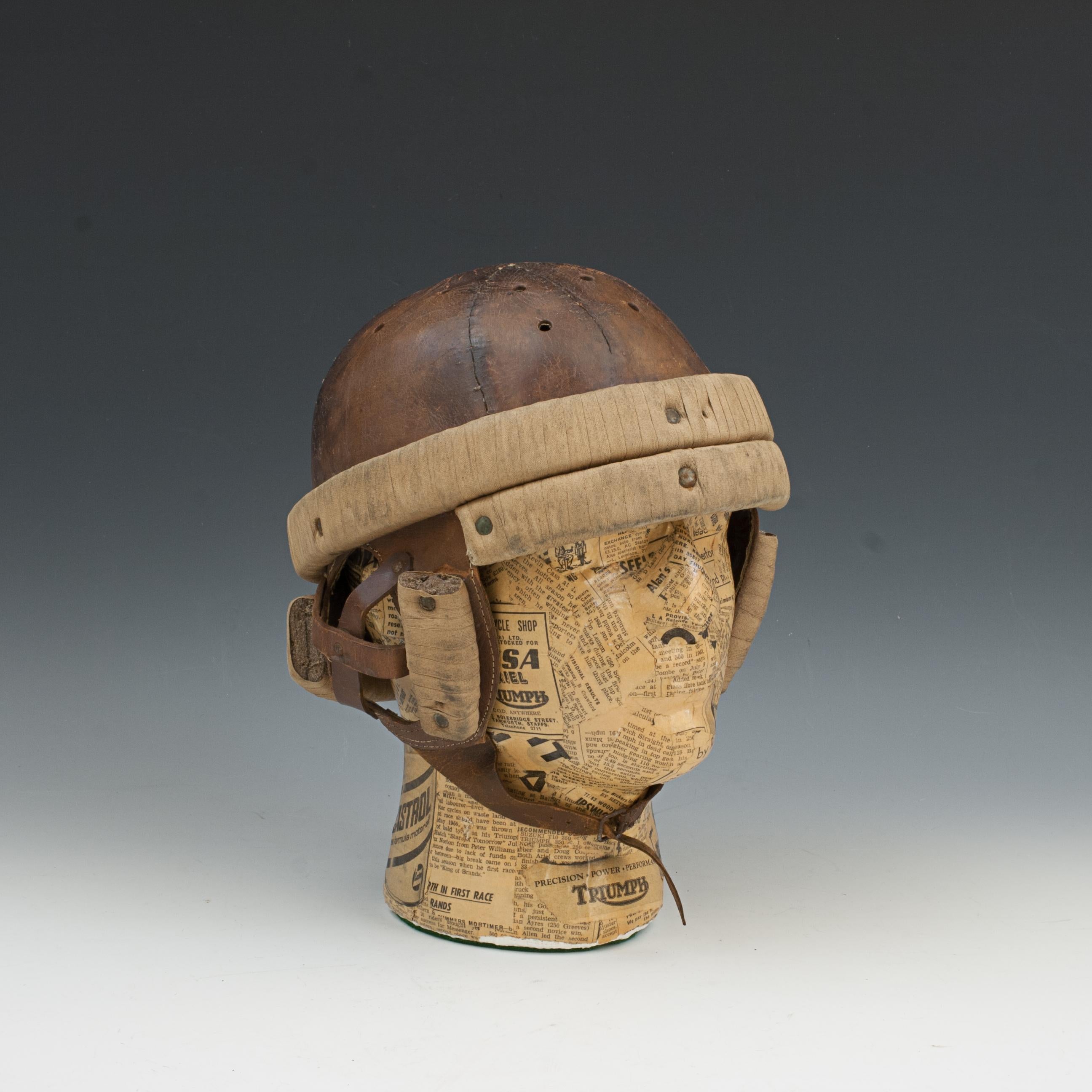 Unusual Leather Helmet.
A very unusual leather helmet with padded protection. The hard leather shell is stitched together and has ventilation holes in the top. There is padded protection bars, one all around the circumference, a small one for the