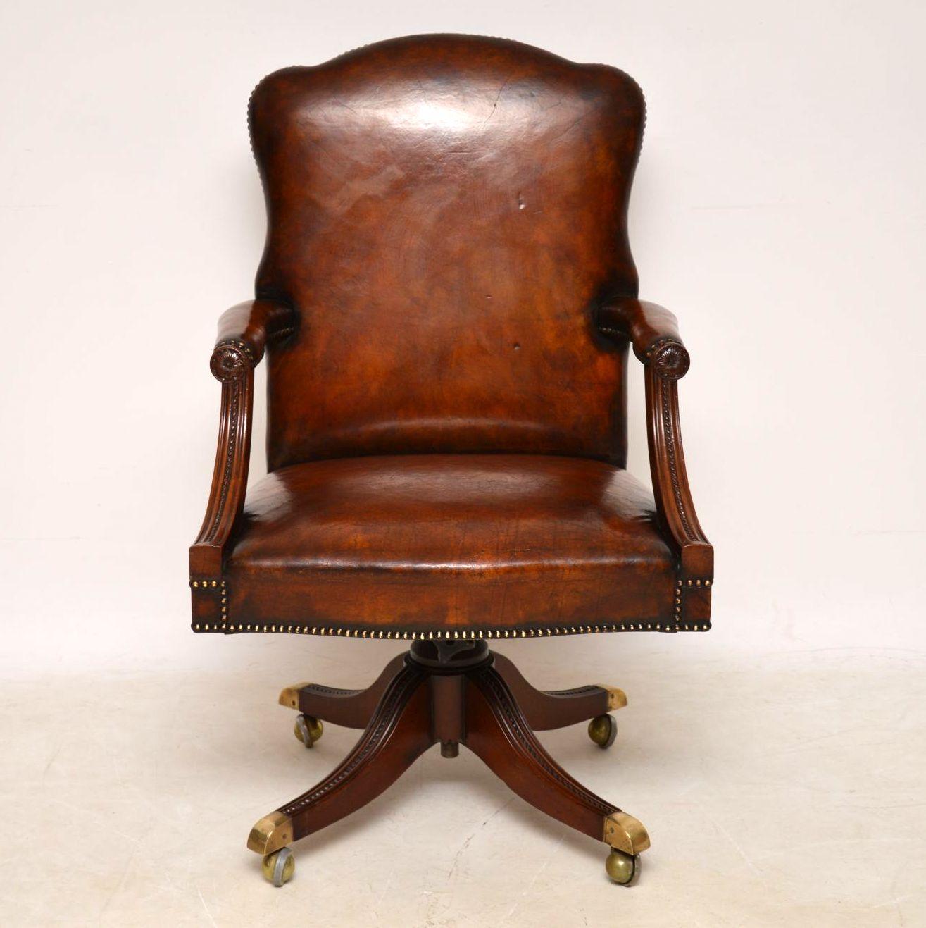 Antique leather and mahogany swivel desk armchair in good condition and of fine quality. The original leather upholstery is still in good condition and has a lovely color with plenty of character and is all hand tacked onto the frame. The mahogany