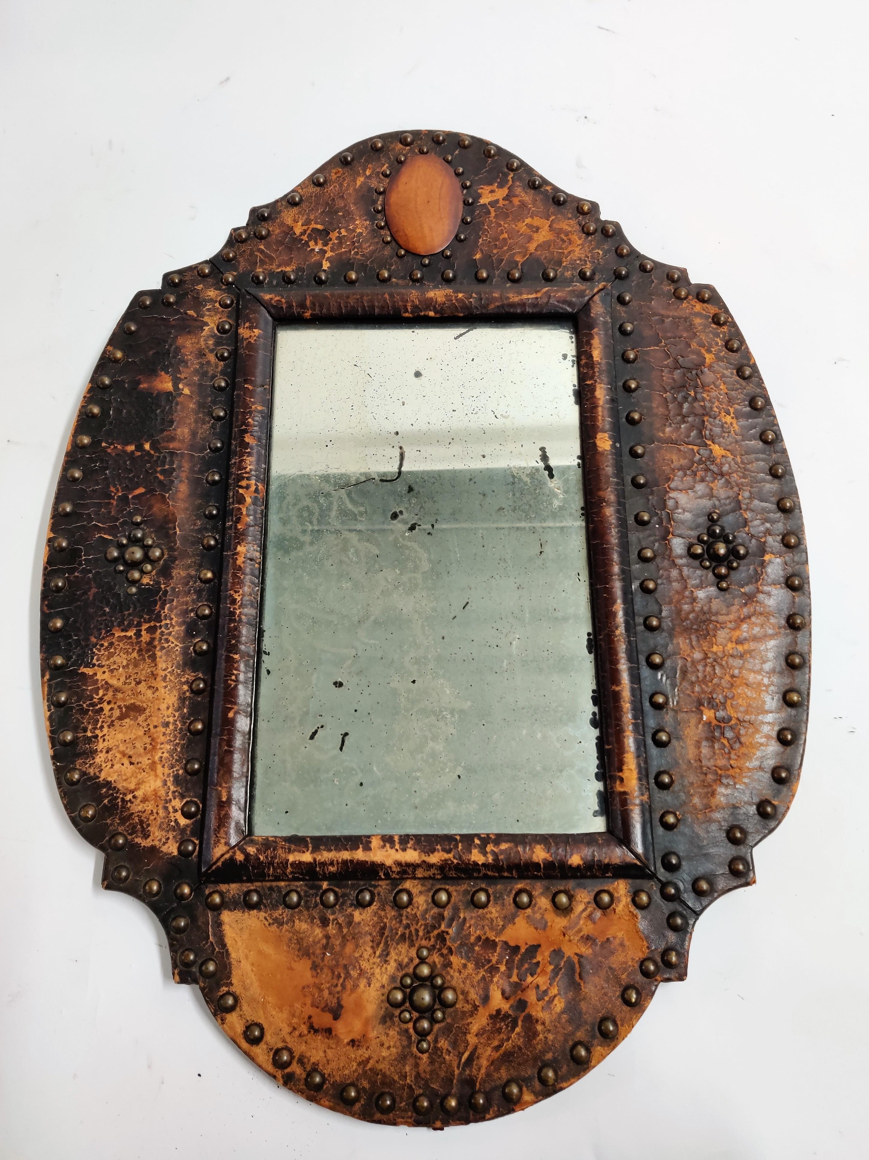 Mid-19th century leather mirror.

This mirror has aged in a beautiful way with worn leather and a patinated mirror.

Very decorative and characteristic piece.

1850s, France

Measures: Height 70 cm/27.5