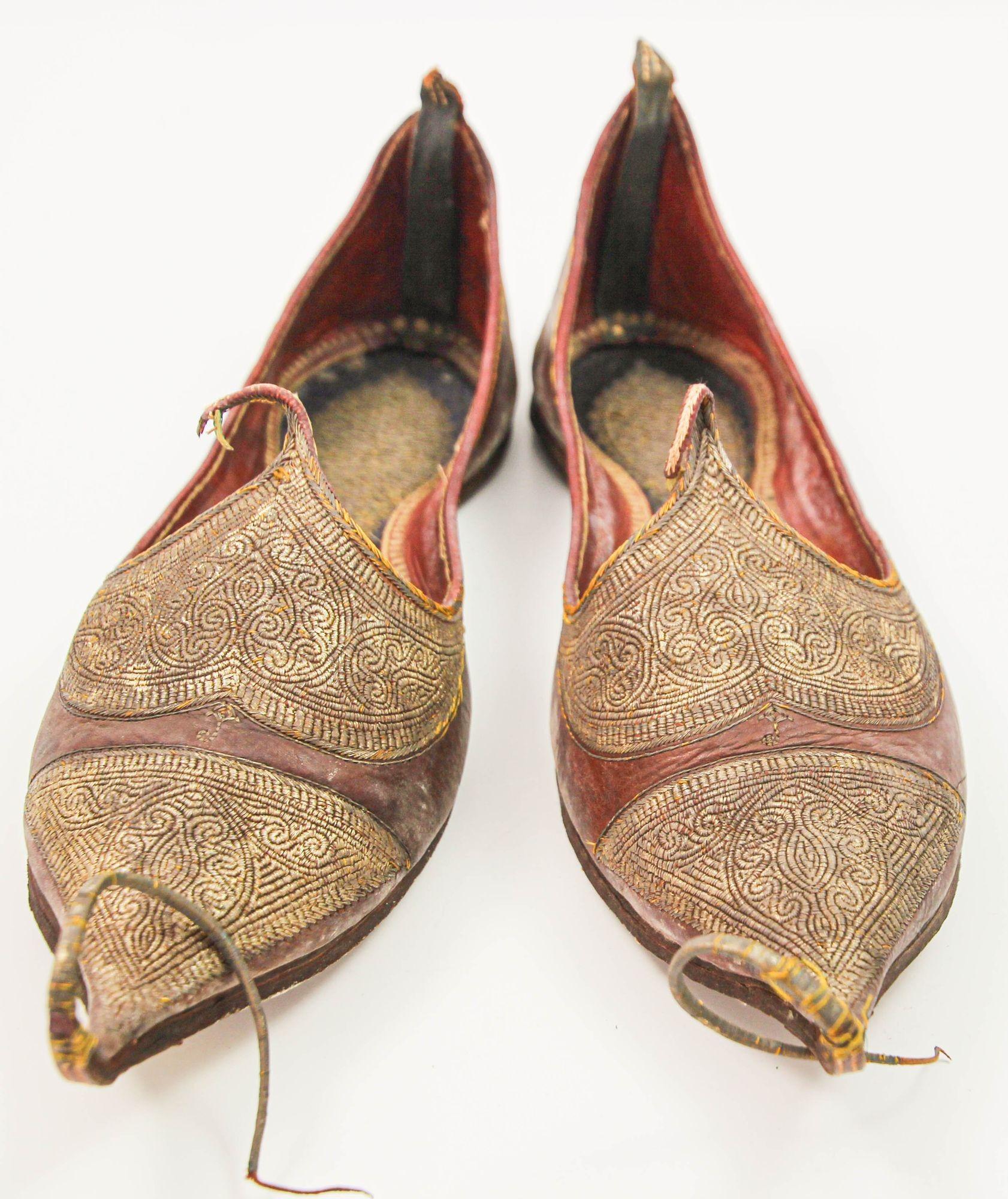 Antique Leather Mughal Moorish Turkish Ottoman Shoes with Gold Embroidered.
A pair of rare late 19th century hand stitched and hand tooled leather shoes with hand embroidered with gilt metallic threads.
Measures: 11