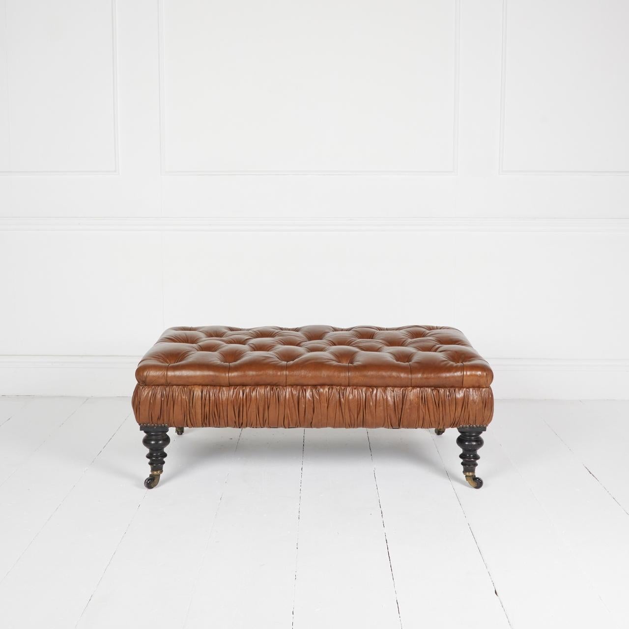 Tabouret ottoman anglais en cuir ancien recouvert de cuir italien vieilli avec bordure froncée

reposant sur des pieds tournés ébonisés et des roulettes d'origine.

Dimensions : H 15″  L 42″ D 25″

Ref MS167