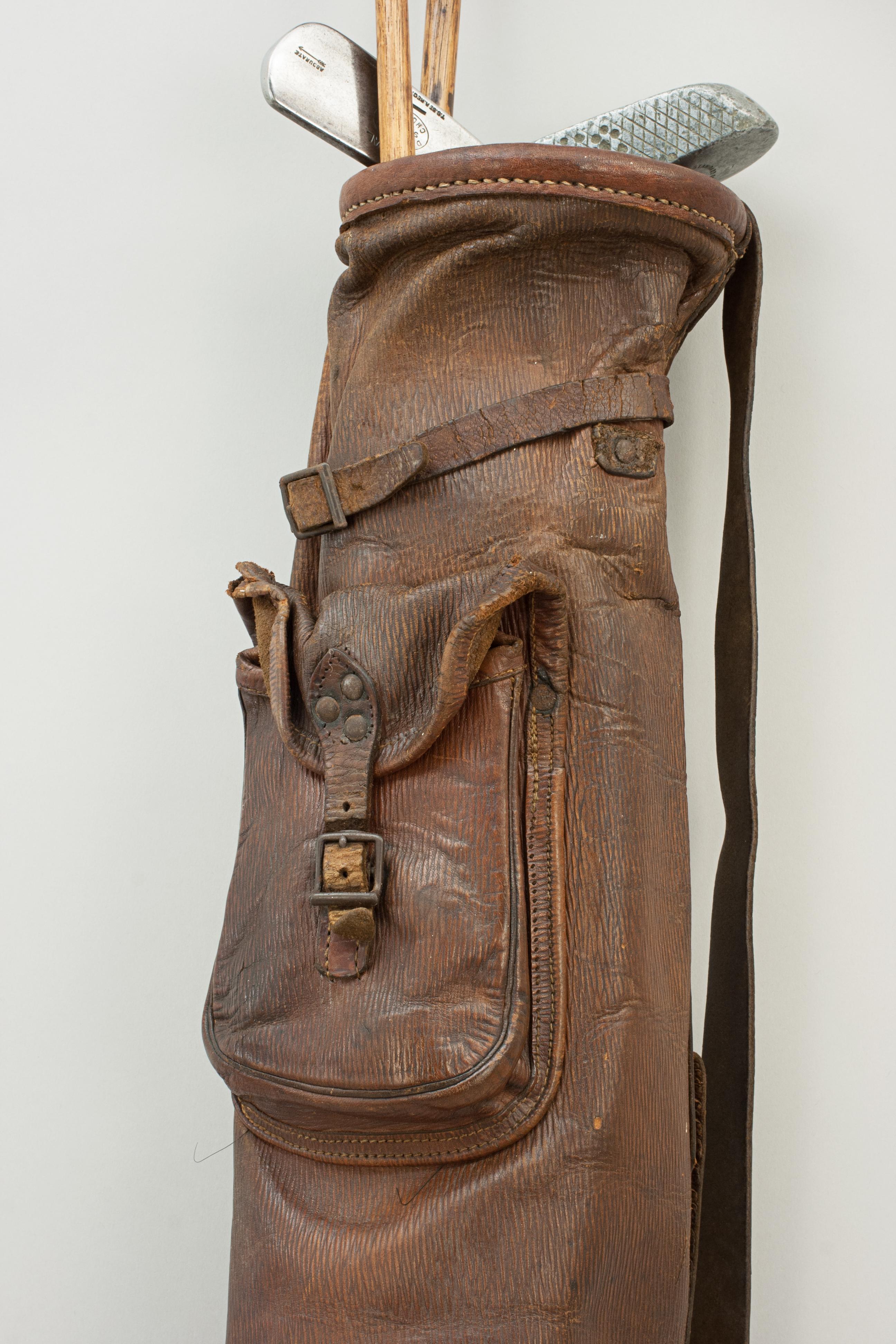 Leather pencil golf bag.
A nice small leather pig skin pencil golf bag with shoulder strap and pocket. The stitching on the bag is fragile so not a usable bag but a great display piece for your hickory golf clubs.

Golf clubs not included, but do