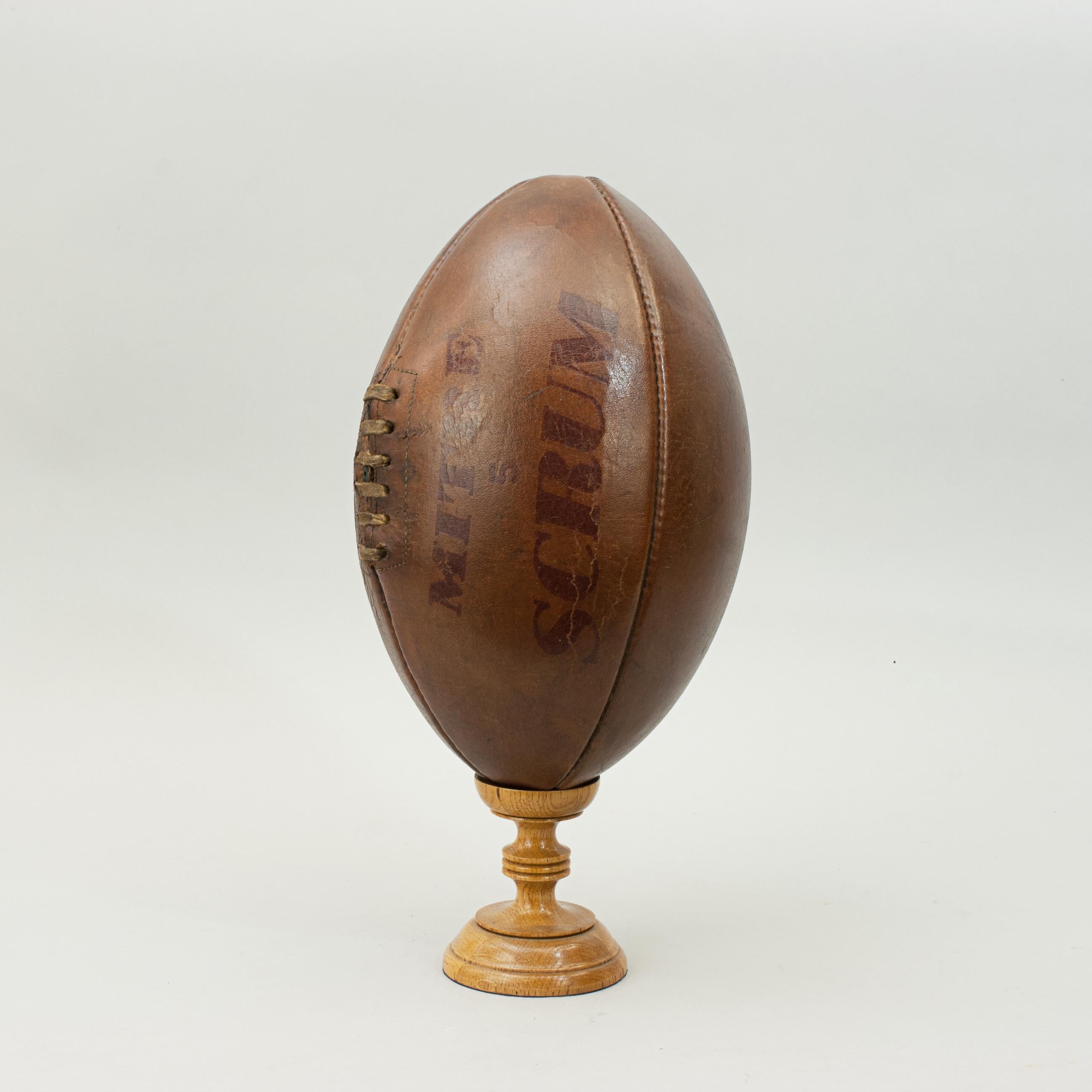 Vintage leather rugby ball.
A traditional Mitre No. 5 leather rugby ball with a lace-up slit to the top and valve for bladder inflation. The ball is with good brown color. A nice four-panel rugby ball embossed 'Mitre 5 Scrum' on one panel and