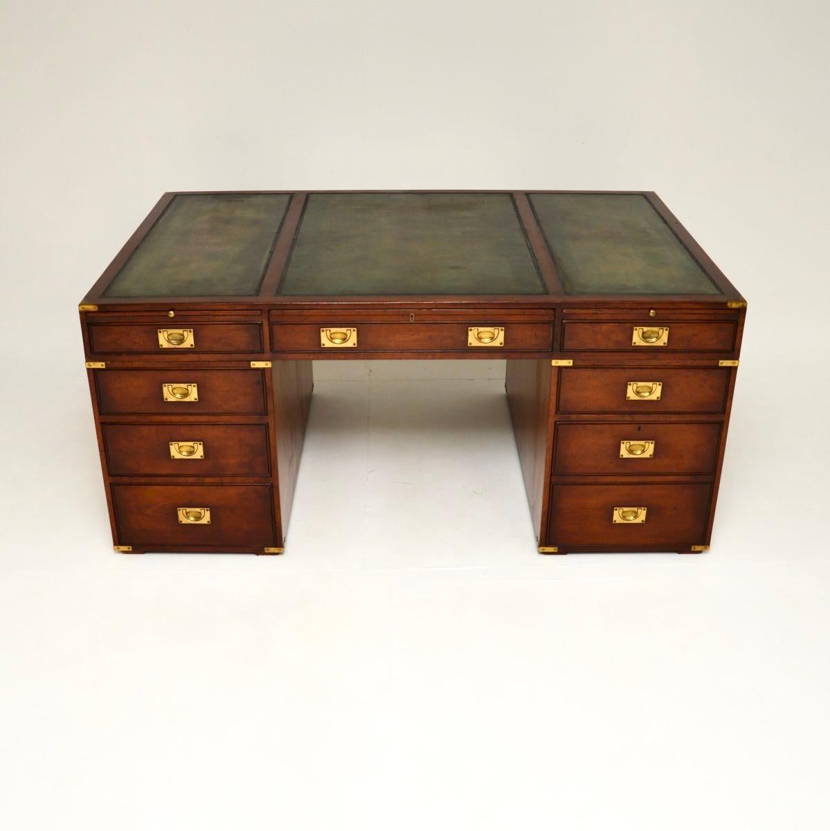 A superb antique military campaign style partners desk. This was made in England, it dates from around the 1950’s.

It is of outstanding quality, it is a large, useful and impressive size. There is plenty of work space and storage space within the