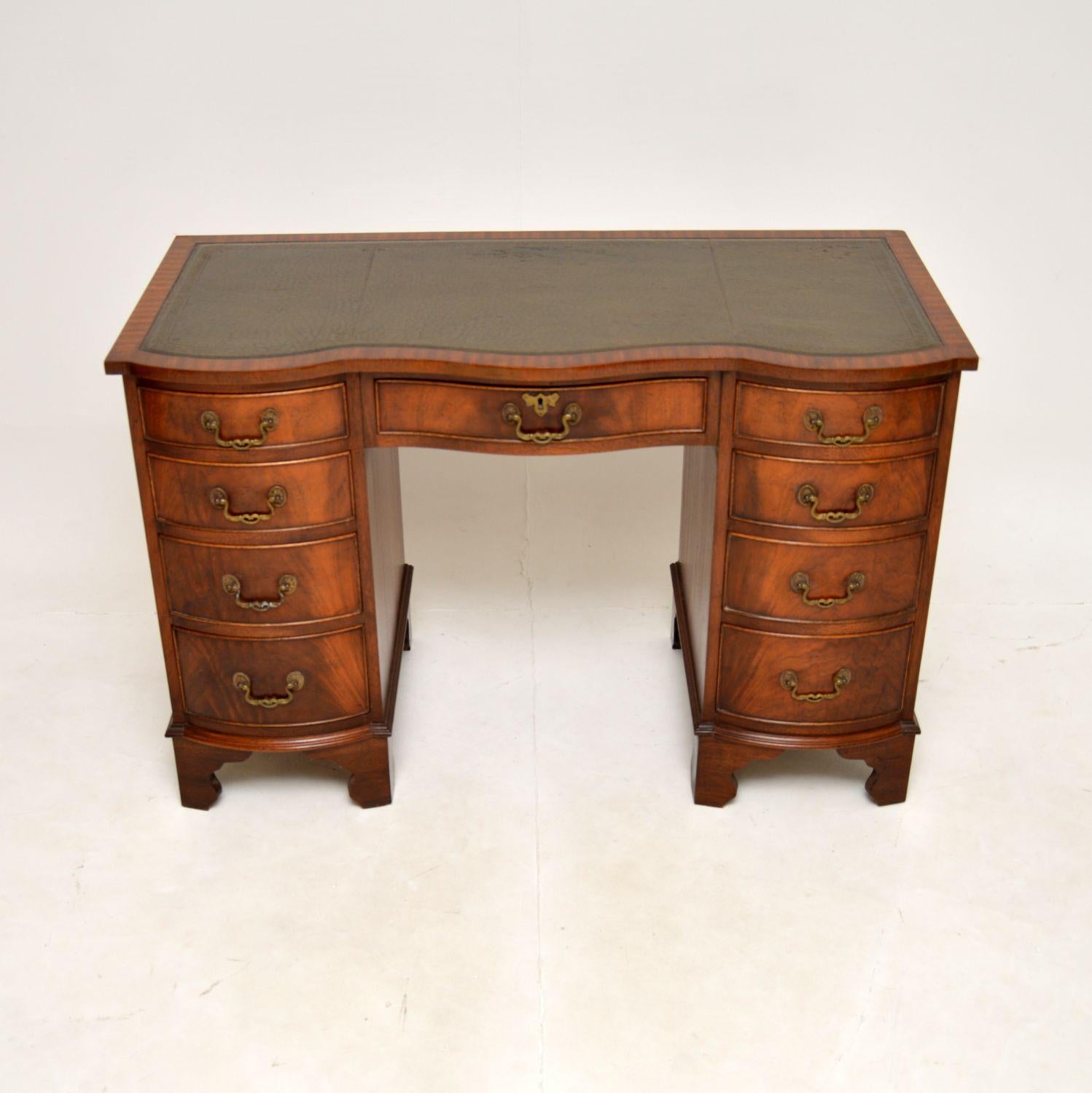 A smart and very well made antique leather top pedestal desk. This was made in England, it dates from around the 1950’s.

It is of superb quality and is a very useful size. This has a serpentine shaped front, it sits on bracket feet and has a lovely
