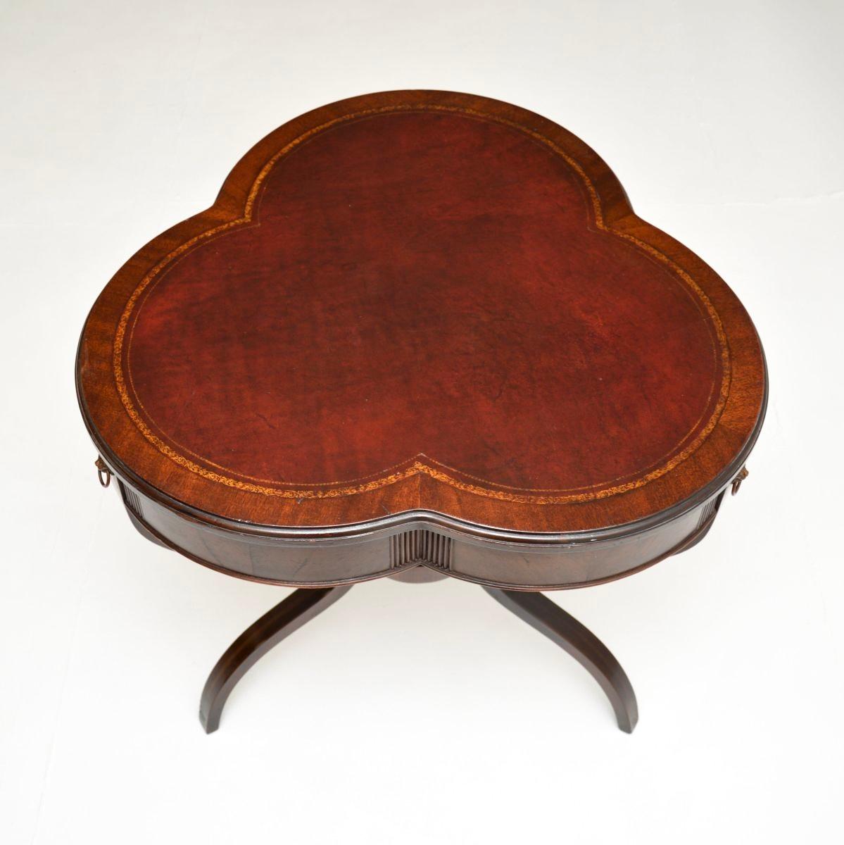 A beautiful and quite unusual antique leather top occasional table. This was made in England, we would date it to around the 1920-30’s.

It is of superb quality and has a lovely clover shaped design to the top. The top has an inset burgundy leather