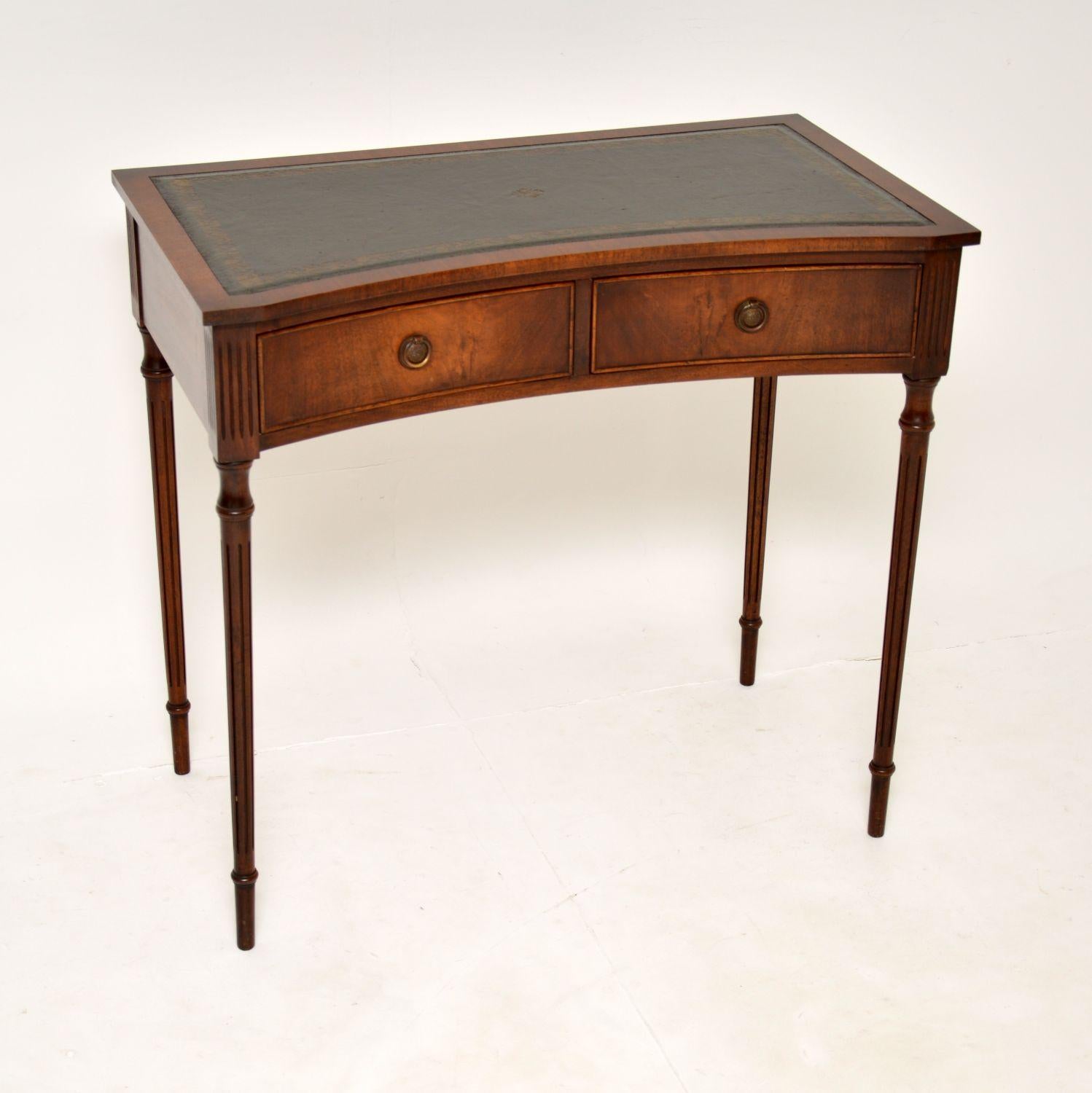 A beautiful and elegant concave fronted writing table in the antique Regency style. This was made in England & I would date it from around the 1950’s period.

It has a wonderful design and shape and is of excellent quality. The concave drawers