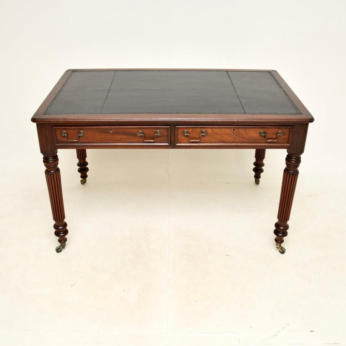 A fantastic antique leather top writing table / desk. This was made in England, it dates from around the 1930-50’s.

The quality is outstanding, it stands on boldly turned and fluted legs with brass casters, it has a gorgeous inset faded black