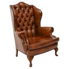 Fauteuil ancien en cuir à dossier en forme d'aile