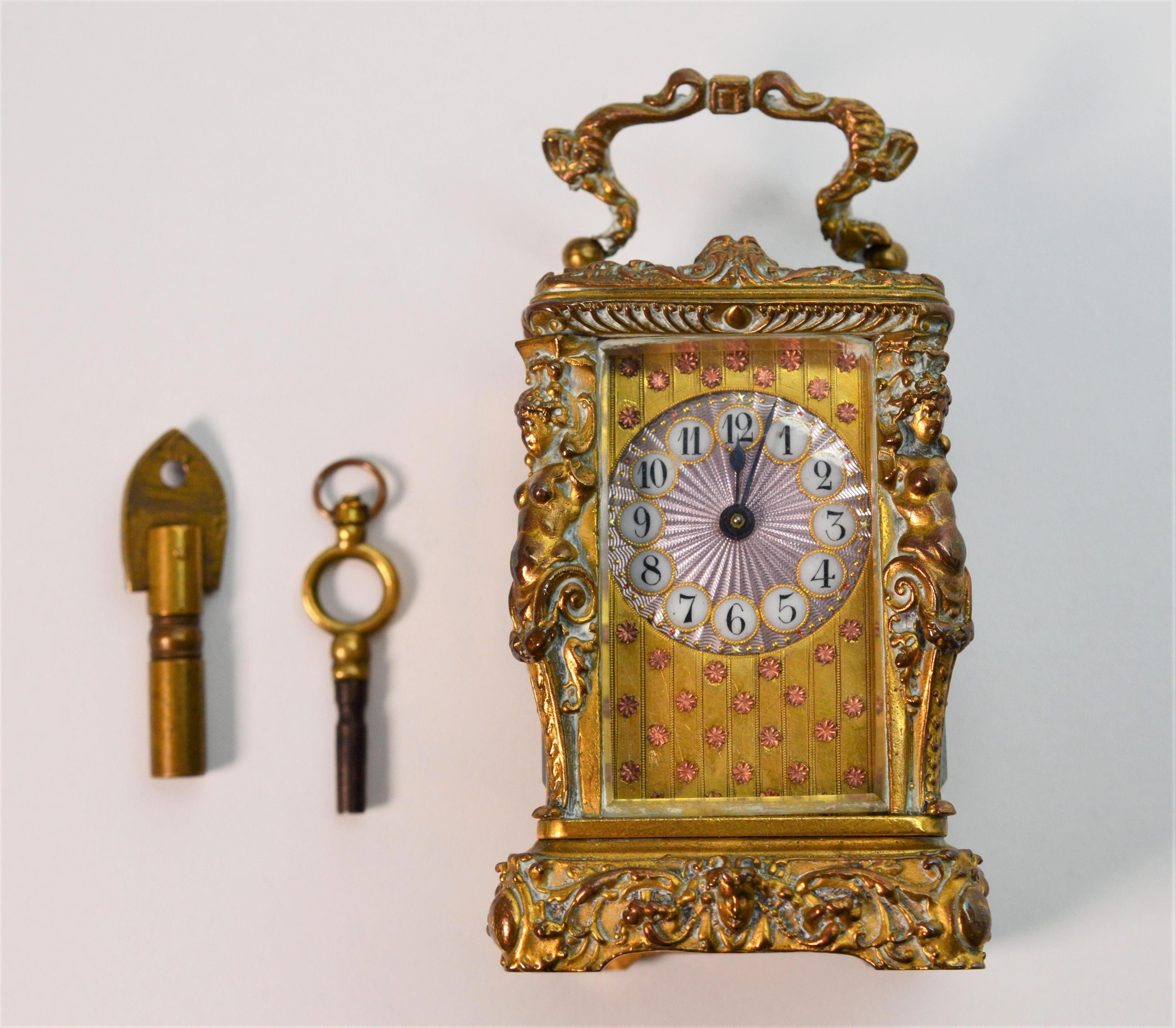 Charming heirloom vanity piece made by one of Europe finest clock maker's . This adorable gilded brass antique miniature L'Epee Carriage Clock measures 
2-1/2 inches high x 1-1/2 W x 1-1/2 deep. Made in France, the face has pink guilloche enamel