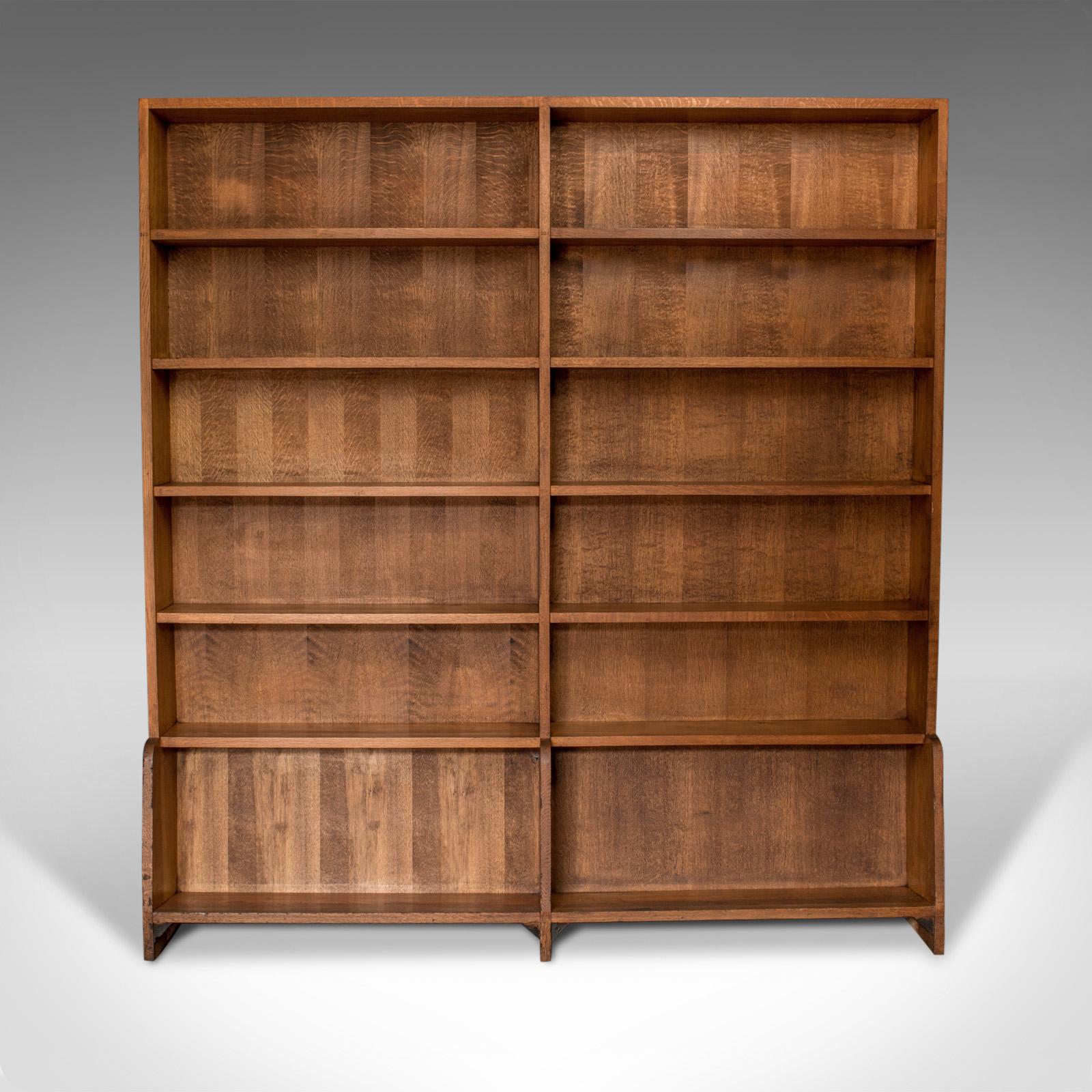 This is an antique library bookshelf. An English, pitch pine, double sided bookcase. A tall room divider dating to the early 20th century, circa 1910.

Appealing biscuit tones in a lustrous wax polished finish
Grain interest and a desirable aged