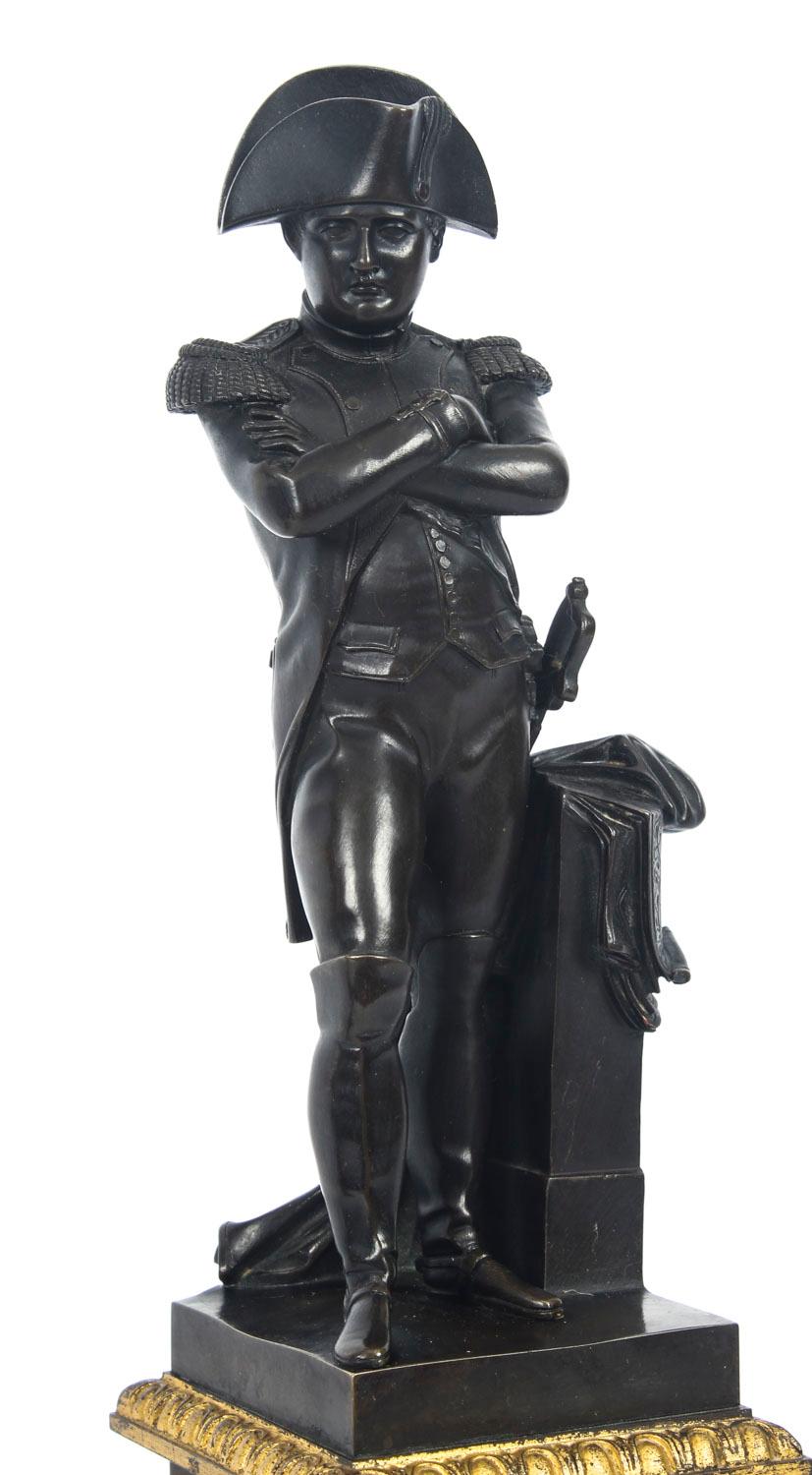 This is a finely cast brown patinated bronze and ormolu library sculpture of Napoleon Bonaparte attributed to Emile Guillemin (1841-1907), late 19th century in date.
 
It features Napoleon standing contrapposto in uniform wearing a bicorn hat,