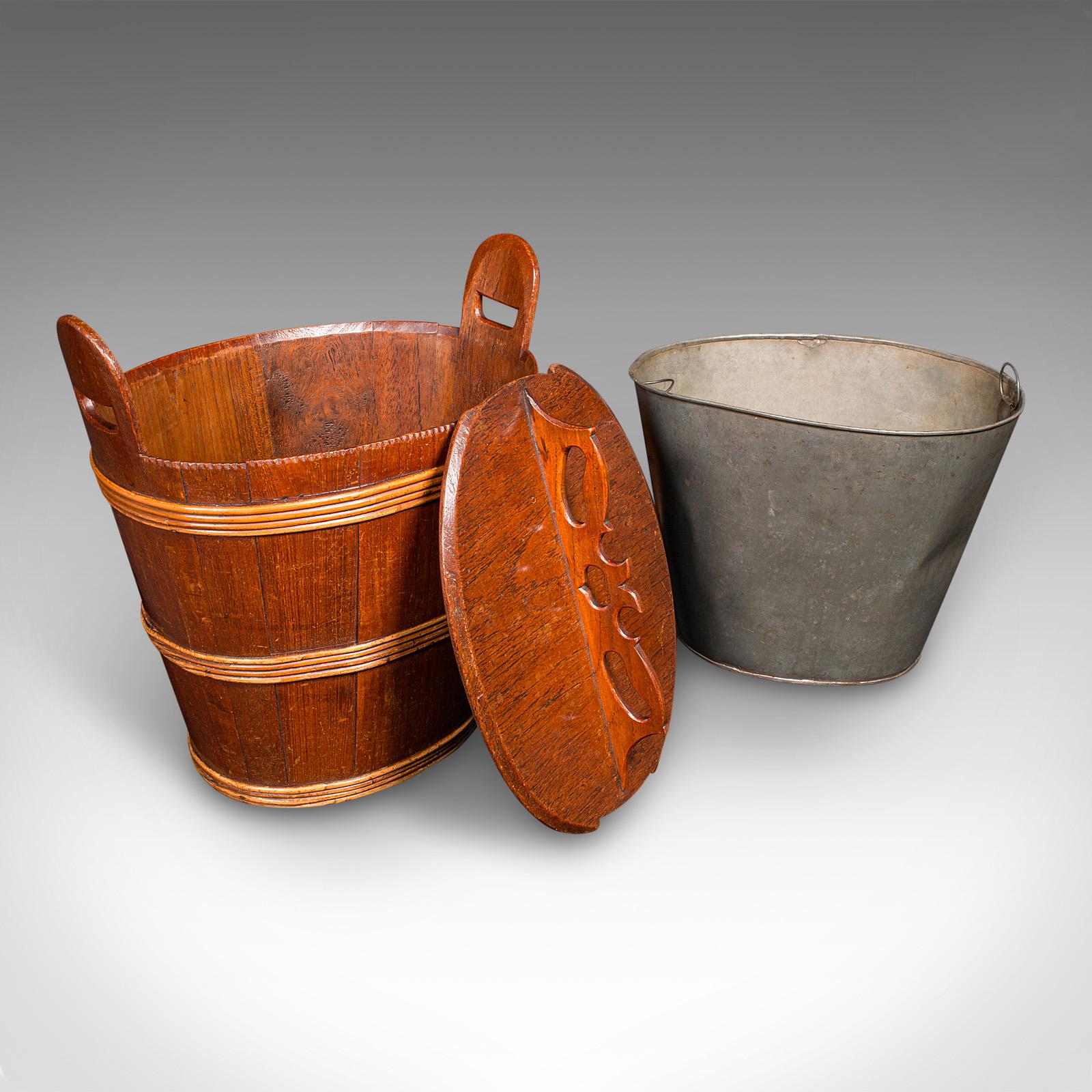 This is a fine antique Georgian period lidded waste bin, presenting as a distinguished Dutch fireside store in oak and fruitwood, circa 1800. This versatile antique is ideal for use as an elegant waste paper bin or refined fireside fuel store,
