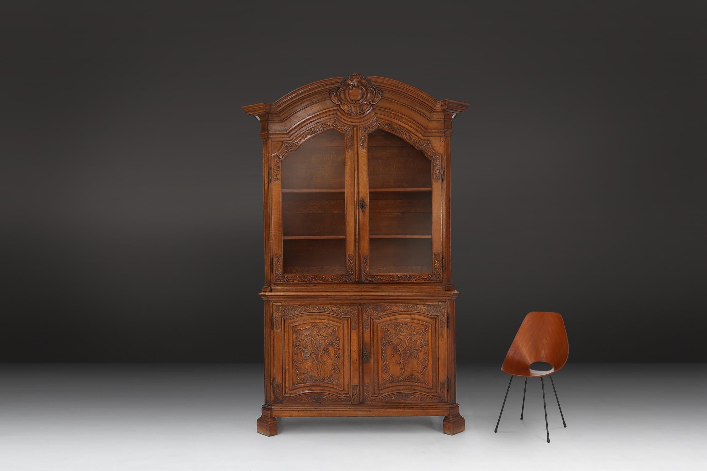 This beautiful antique Liège cabinet is a real eye-catcher in any interior. With its fine carvings and glass doors, this cabinet is the perfect way to display your valuables. The cabinet is made of high quality wood and has a rich history dating